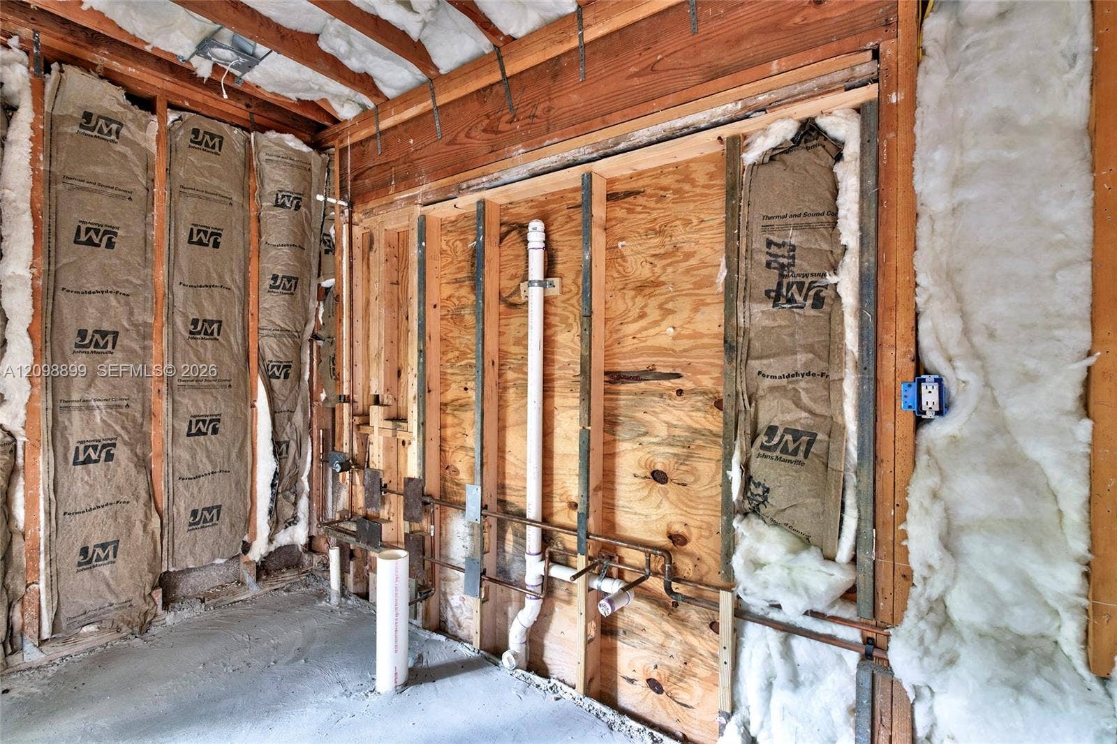 1176 SW 4th Street, Boca Raton, FL 33486 Exposed wall studs with integrated thermal insulation, visible plumbing rough-in, vertical PVC piping, and electrical conduit