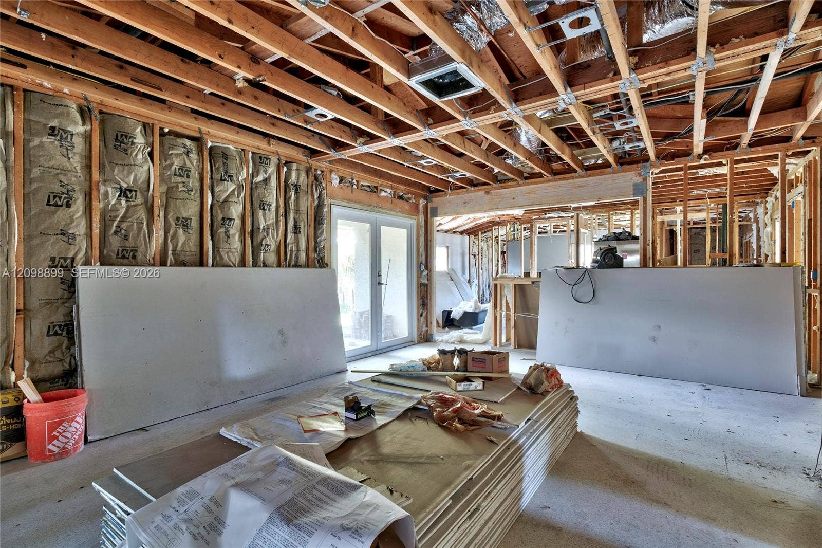 1176 SW 4th Street, Boca Raton, FL 33486 Structural interior space featuring exposed wood framing, installed fiberglass batt insulation, and dual-pane glass entry doors