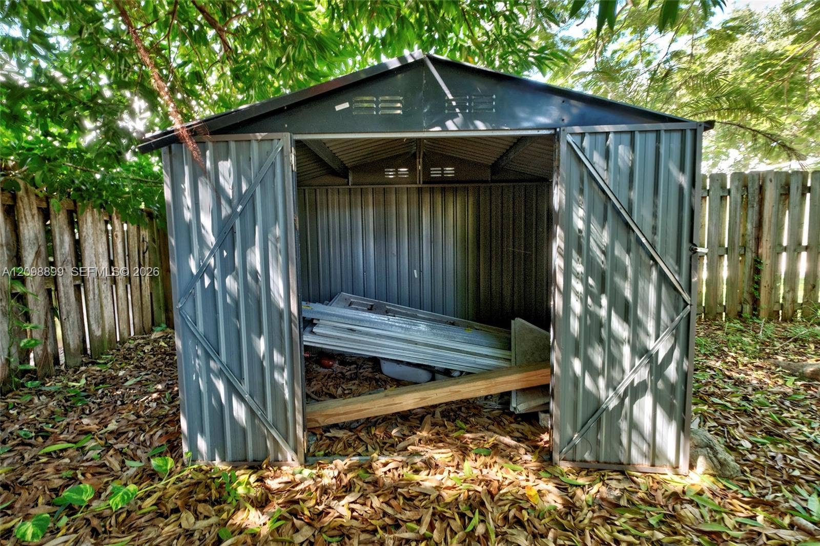 1176 SW 4th Street, Boca Raton, FL 33486 Corrugated metal storage shed featuring a peaked roof and dual swinging doors