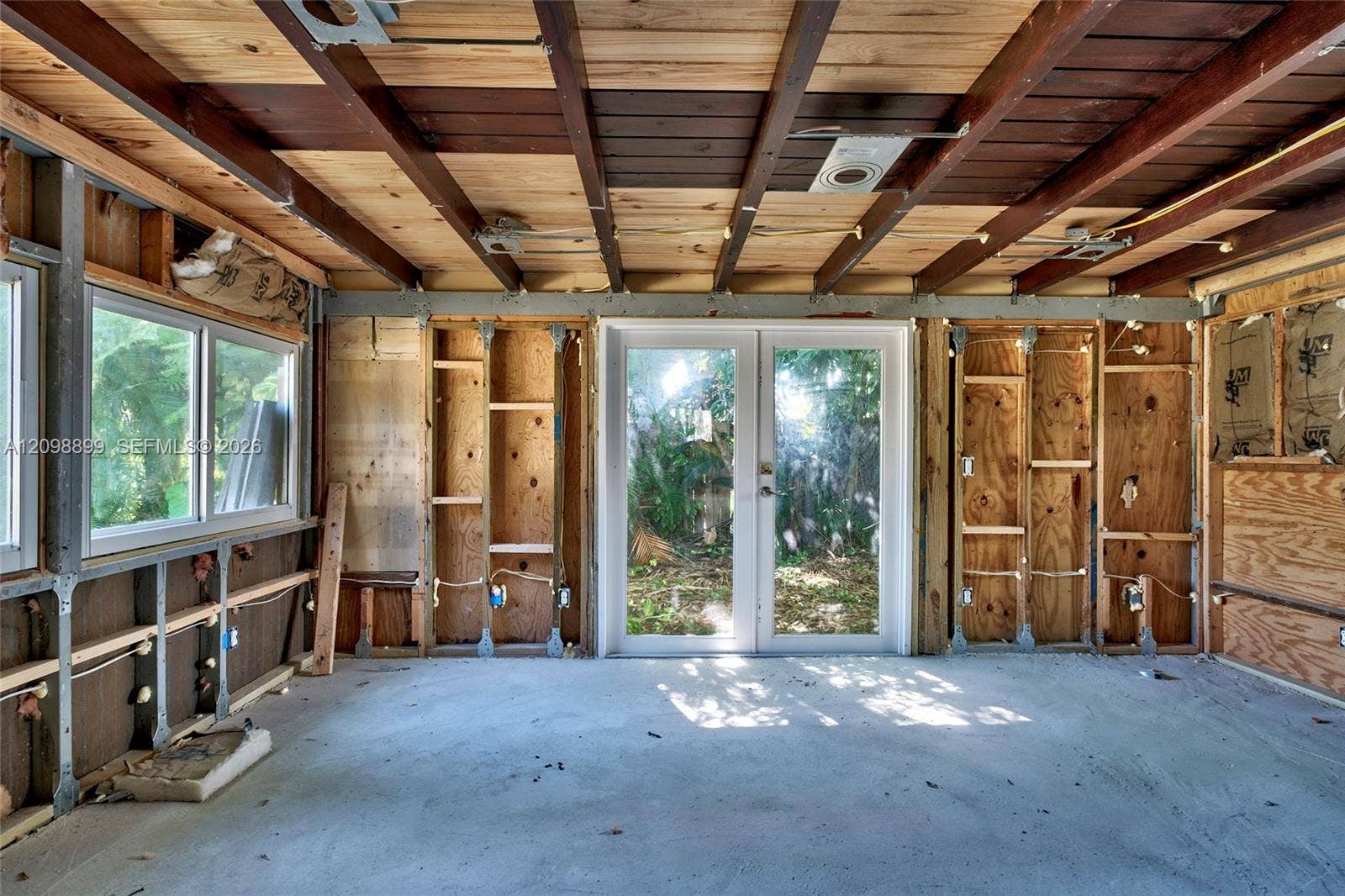 1176 SW 4th Street, Boca Raton, FL 33486 Exposed wood-beam ceiling, glass-paned double doors, dual-pane windows, and concrete flooring