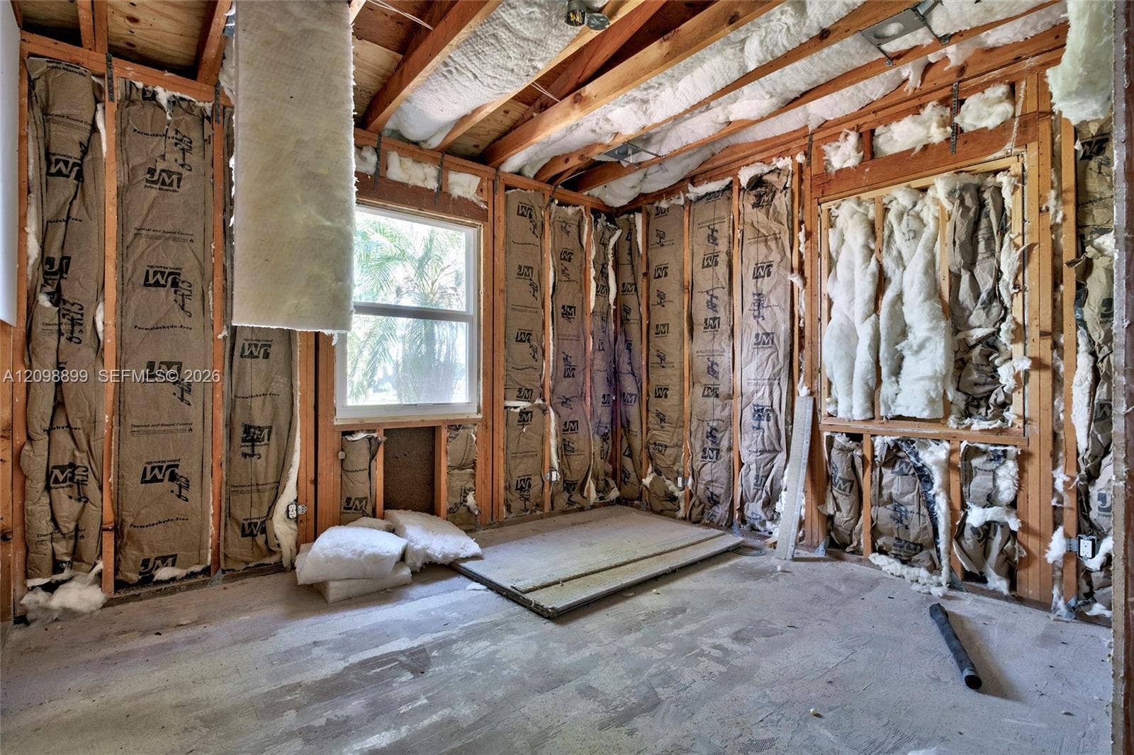 1176 SW 4th Street, Boca Raton, FL 33486 Exposed wood-stud wall framing, batt insulation, single-hung window, and unfinished subflooring