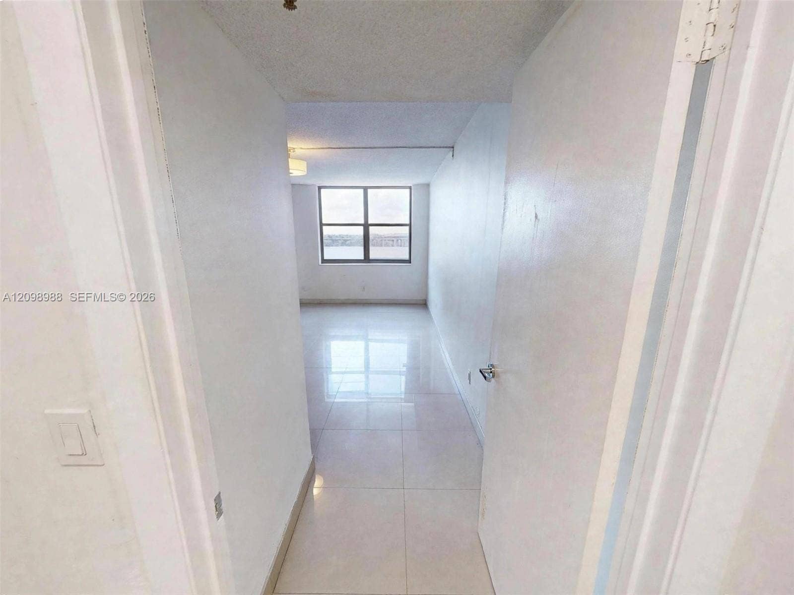 Large-format tile flooring, light-reflective surfaces, and a multi-pane window allowing natural light