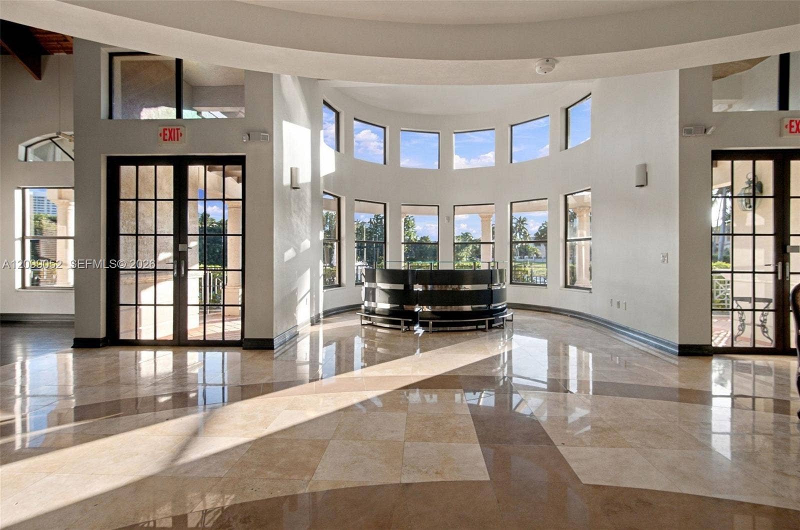 1516 Breakwater Terrace, Hollywood, FL 33019 Rotunda interior featuring polished stone flooring, a multi-paneled curved window wall, and dual glass-paned double doors