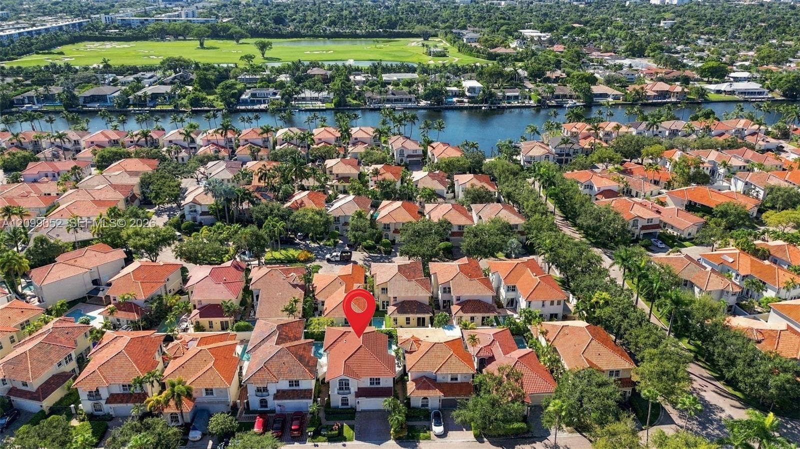 1516 Breakwater Terrace, Hollywood, FL 33019 Aerial perspective featuring a two-story residence with a clay tile roof, private swimming pool, and concrete driveway