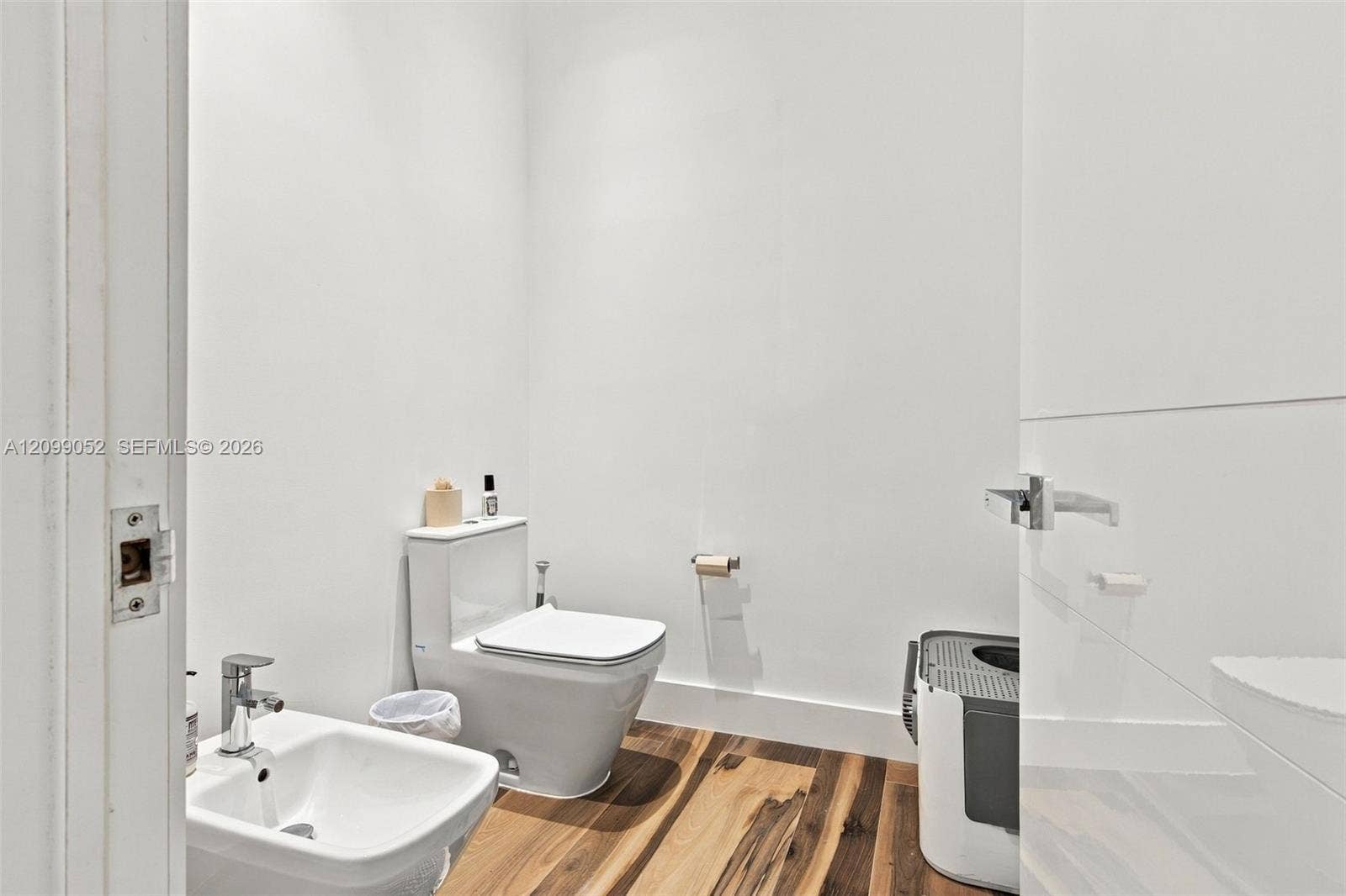 1516 Breakwater Terrace, Hollywood, FL 33019 Bathroom featuring wood-finish flooring, a wall-mounted bidet with a chrome faucet, and a dual-flush toilet