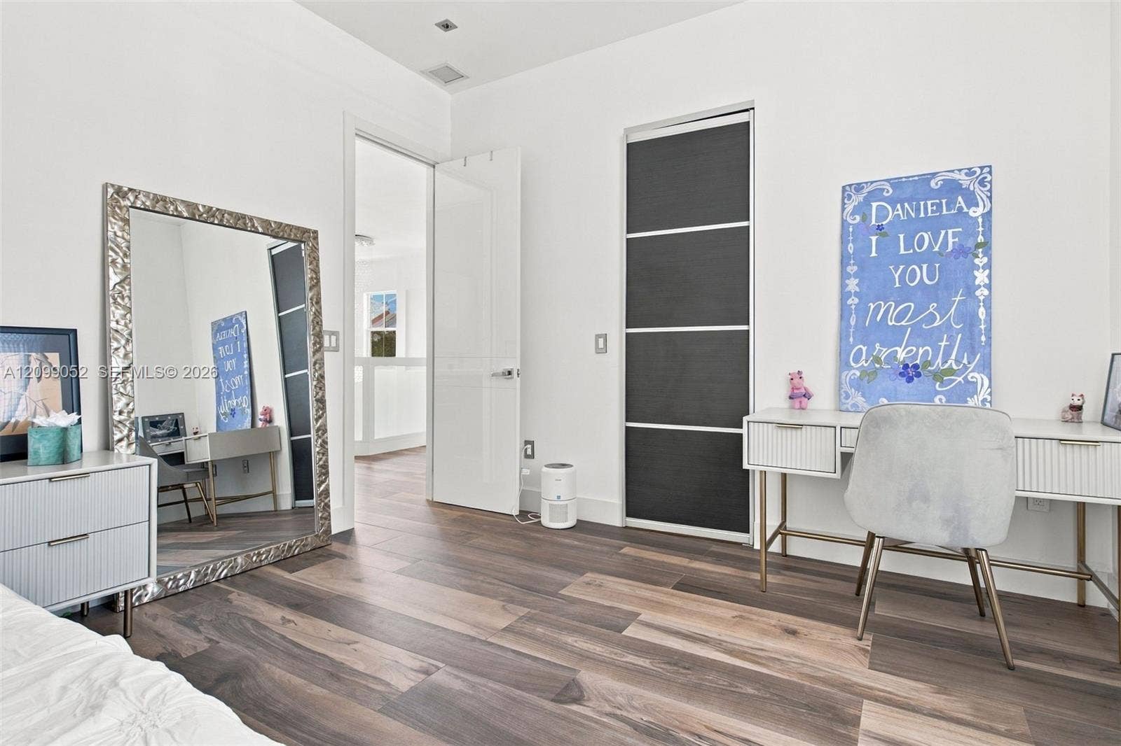 1516 Breakwater Terrace, Hollywood, FL 33019 Room featuring wood-finish flooring, recessed ceiling lighting, and a closet with sliding dark-toned panels and metallic trim