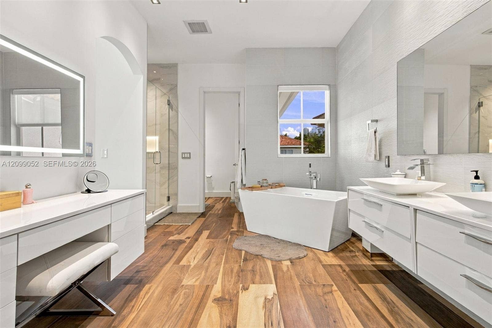 1516 Breakwater Terrace, Hollywood, FL 33019 Wood-finish flooring, dual floating white vanities with vessel sinks, freestanding deep-soaking tub, and walk-in glass-enclosed shower