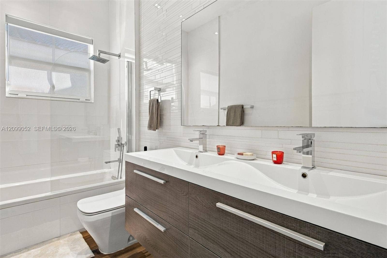 1516 Breakwater Terrace, Hollywood, FL 33019 Floating dual-sink vanity with wood-finish cabinetry, rectangular under-mount sinks, and polished chrome faucets