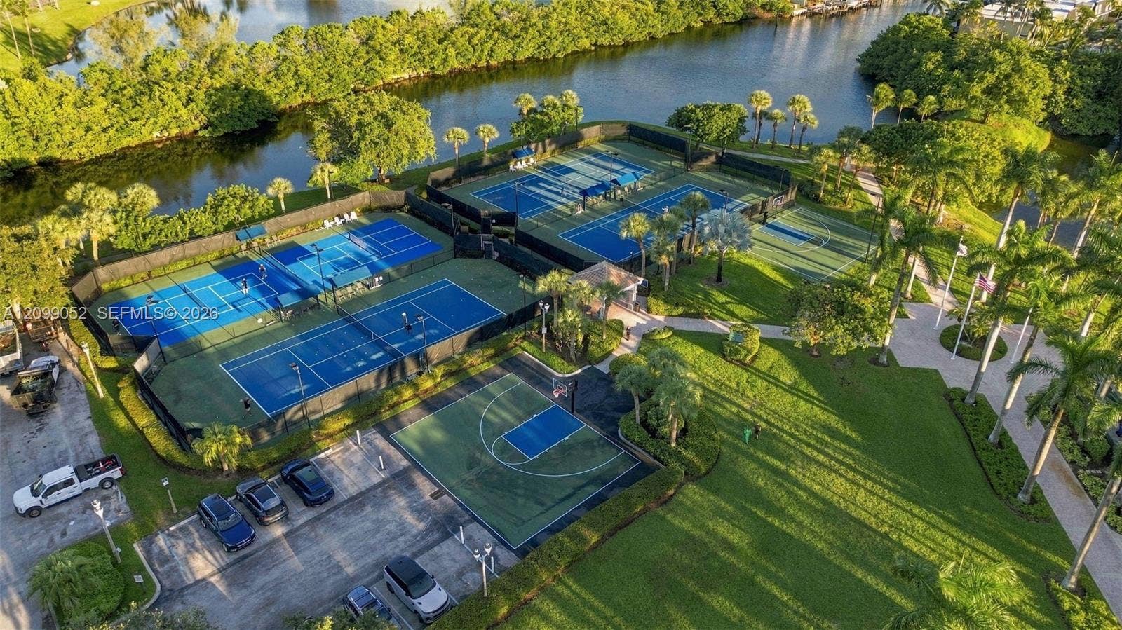 1516 Breakwater Terrace, Hollywood, FL 33019 Recreational area featuring four tennis courts, a basketball court, paved walkways, and water frontage