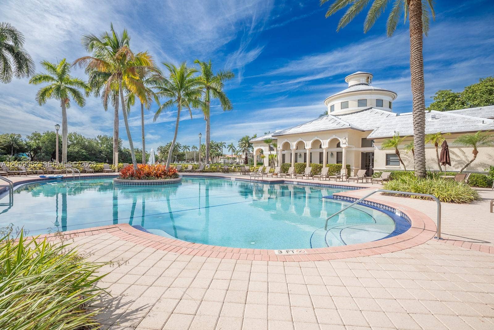 1516 Breakwater Terrace, Hollywood, FL 33019 Swimming pool featuring a sun shelf entry, brick paver coping, and a central landscaped island with palm trees