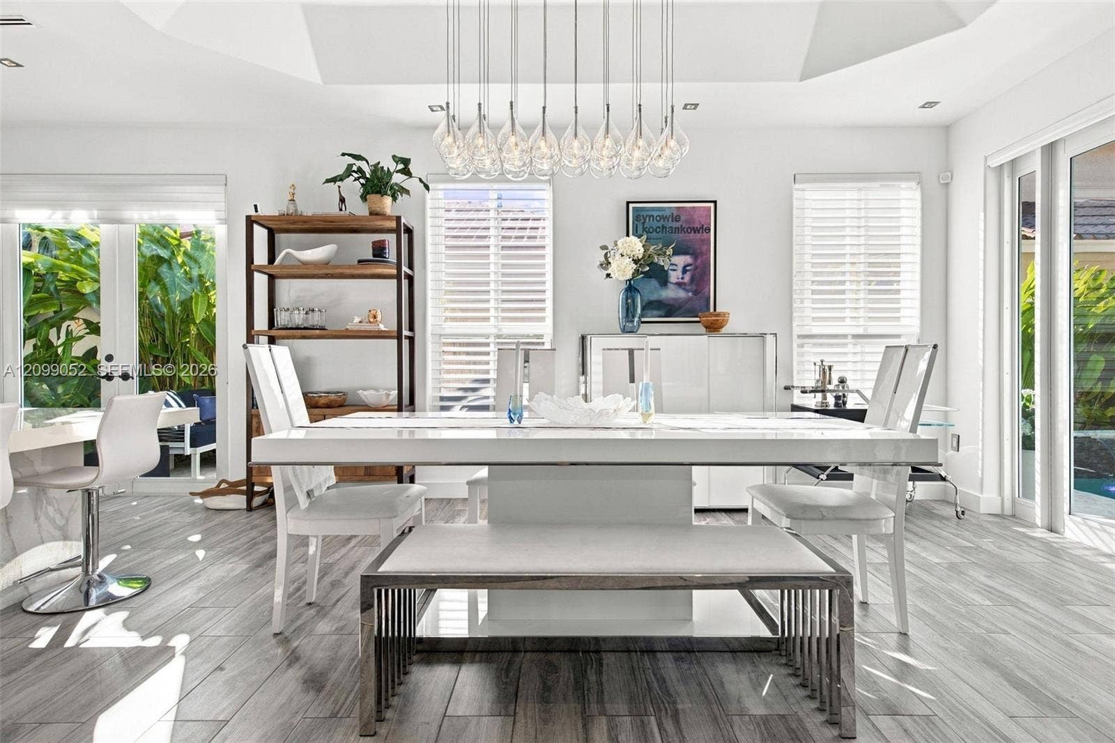 1516 Breakwater Terrace, Hollywood, FL 33019 Dining area featuring a recessed tray ceiling, wood-finish tile flooring, and a multi-pendant chandelier