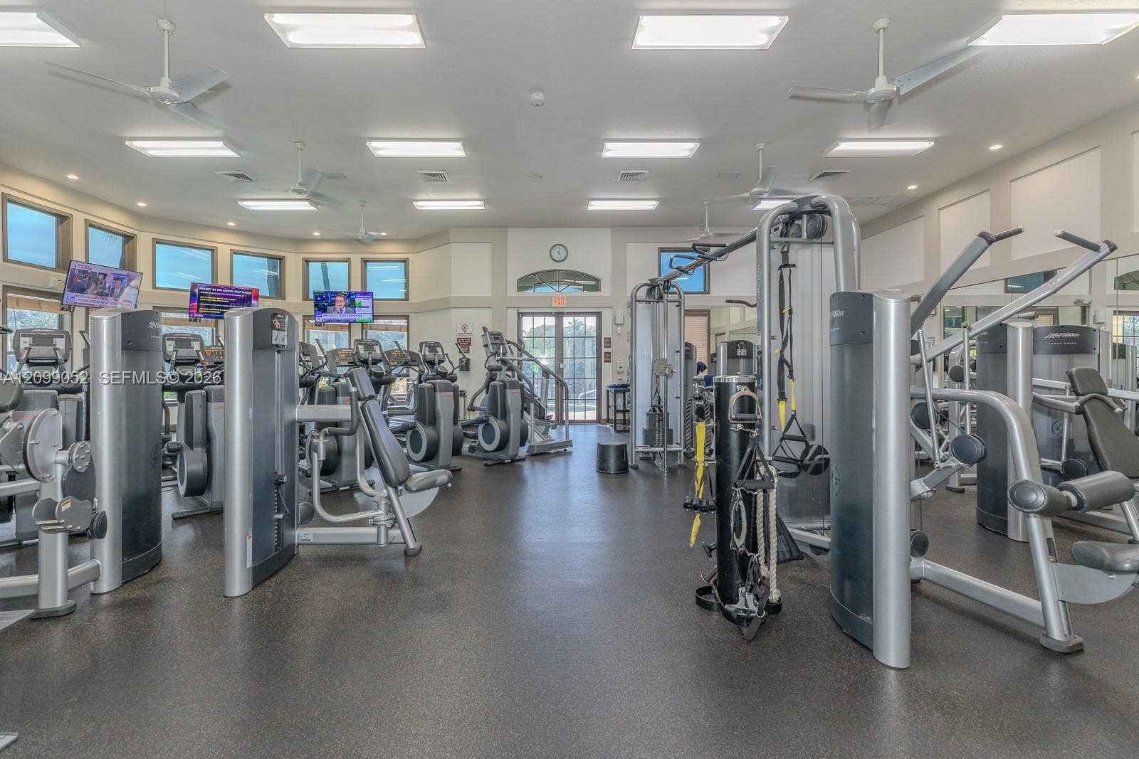 1516 Breakwater Terrace, Hollywood, FL 33019 Fitness center featuring rubber flooring, recessed ceiling lighting, multiple ceiling fans, and an array of weight training and cardio equipment