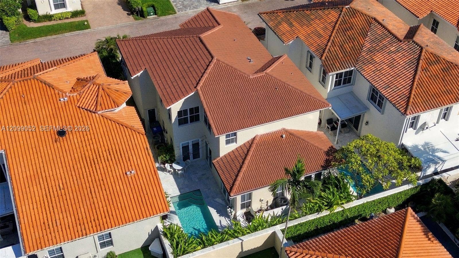 1516 Breakwater Terrace, Hollywood, FL 33019 Aerial perspective of a multi-story residence featuring a terracotta-style tile roof, a private swimming pool, and a walled rear perimeter