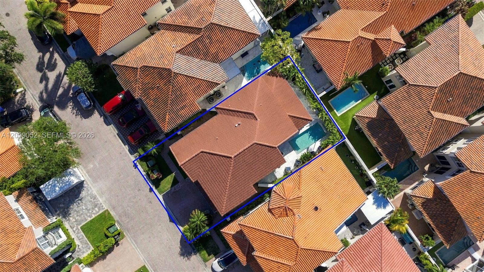 1516 Breakwater Terrace, Hollywood, FL 33019 Aerial view featuring a multi-hipped tile roof, an in-ground swimming pool, and a private fenced yard with mature landscaping