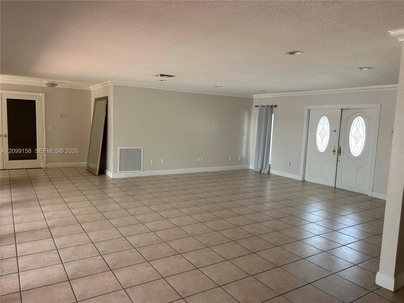 1490 Lenape Drive, Miami Springs, FL 33166 Room featuring neutral wall paint, tile flooring, two multi-tiered crystal chandeliers, and a walk-in closet with built-in shelving