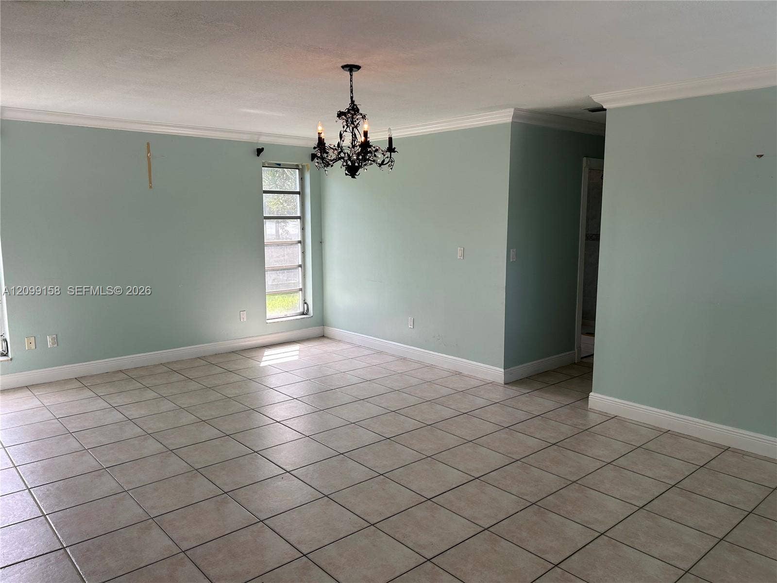1490 Lenape Drive, Miami Springs, FL 33166 Dual-sink vanity with solid-surface countertop and metallic-finish faucets, large wall-mounted mirror, ceramic tile wall and floor surfaces, and built-in jetted soaking tub