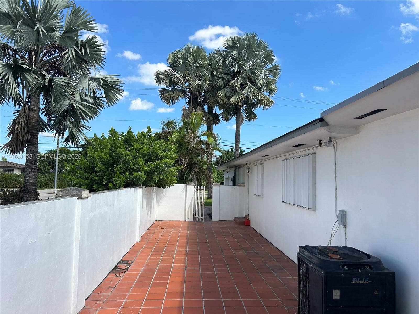 1490 Lenape Drive, Miami Springs, FL 33166 Garage featuring an epoxy floor coating, expansive wall-to-wall light wood-finish cabinetry, built-in storage drawers, and integrated wall-mounted wire grid organization panels