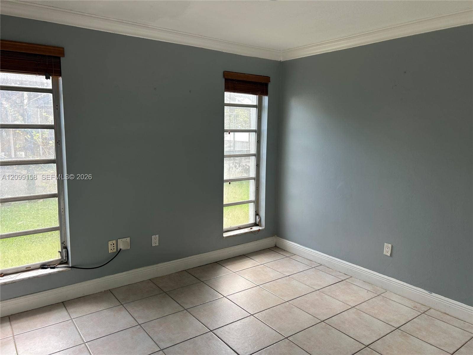 1490 Lenape Drive, Miami Springs, FL 33166 Bathroom featuring a dark-finish vanity with a light-toned countertop, integrated basin, wall-mounted mirror, and tile-surround shower with a glass window