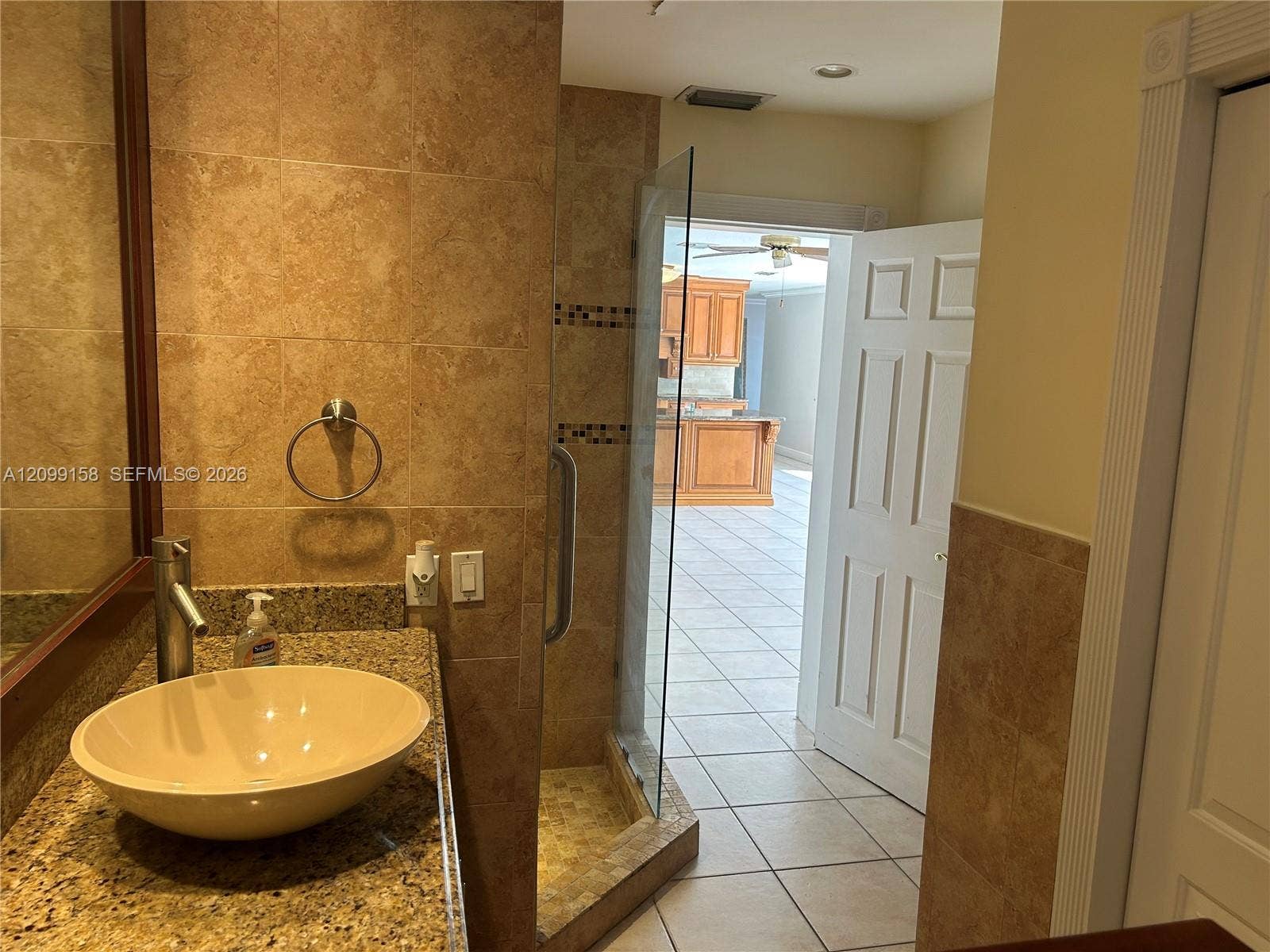 1490 Lenape Drive, Miami Springs, FL 33166 Covered outdoor patio featuring tile flooring, wood-plank ceiling, and dual ceiling fans, highlighted by expansive floor-to-ceiling sliding glass doors