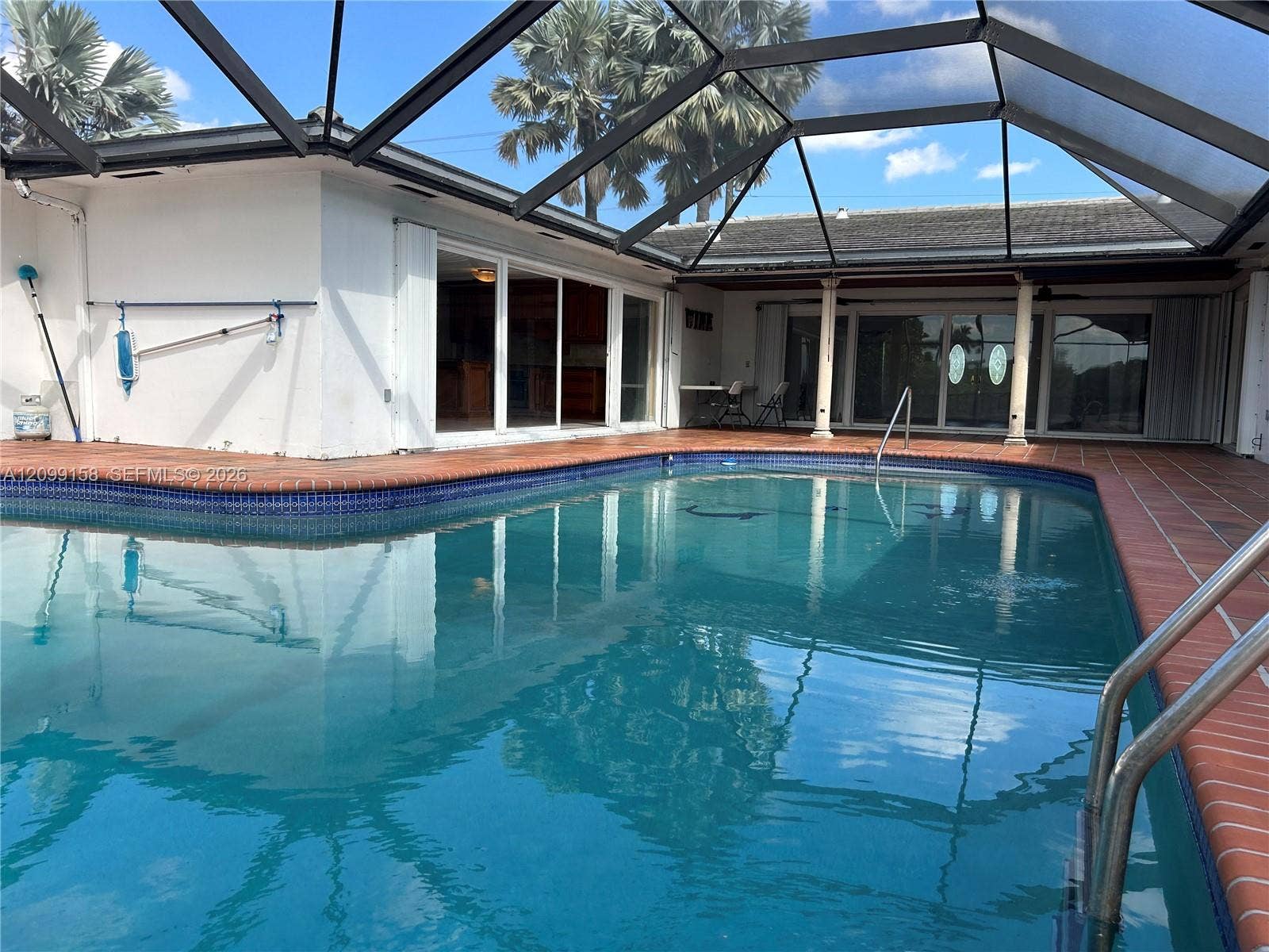 1490 Lenape Drive, Miami Springs, FL 33166 Private exterior courtyard featuring terracotta tile flooring, smooth stucco wall enclosure, and integrated metal gate