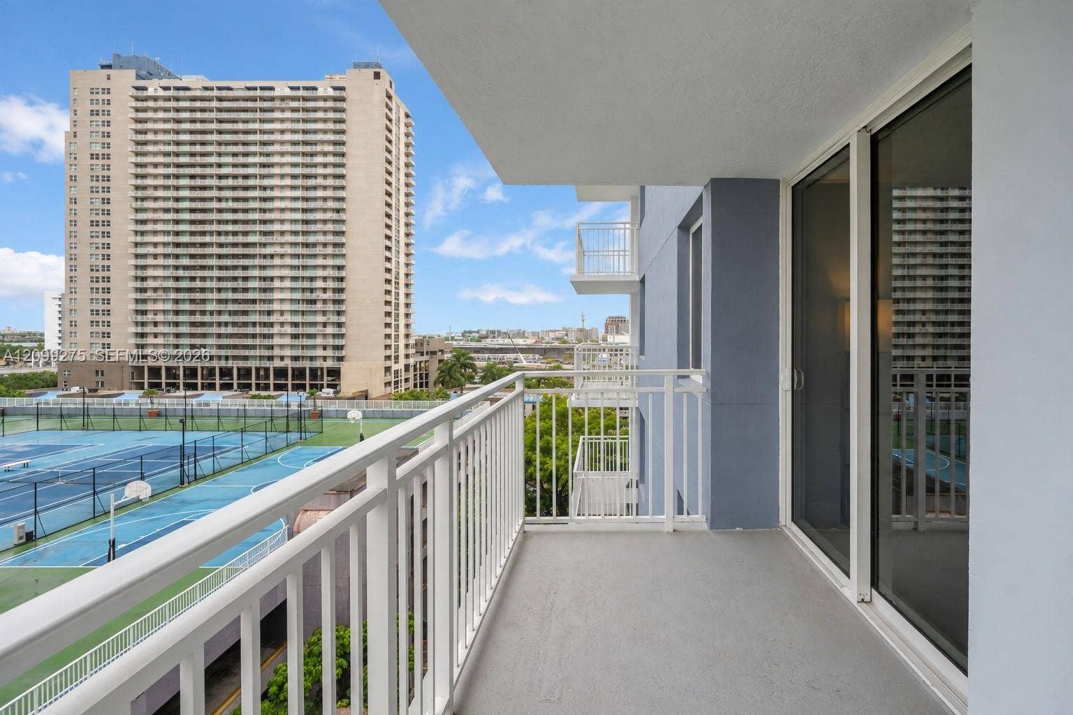 800 N Miami Avenue, #E-902, Miami, Miami, FL 33136 Spacious private balcony featuring white railings and expansive city views, offering an ideal spot to relax and enjoy the open-air setting.