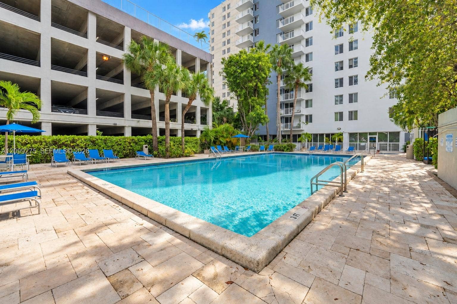 800 N Miami Avenue, #E-902, Miami, Miami, FL 33136 Resort-style swimming pool surrounded by tropical landscaping, spacious sun loungers, and a paved deck, offering residents a relaxing outdoor retreat.