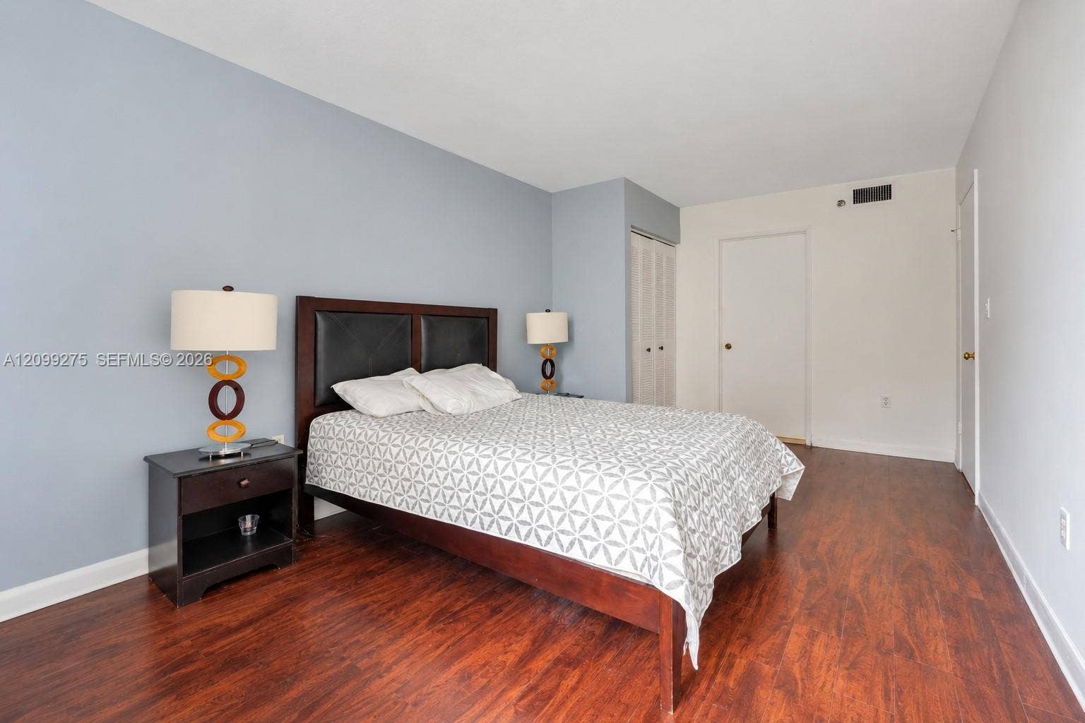 800 N Miami Avenue, #E-902, Miami, Miami, FL 33136 Spacious primary bedroom featuring warm wood flooring, generous closet space, large windows, and a neutral color palette for a comfortable retreat.