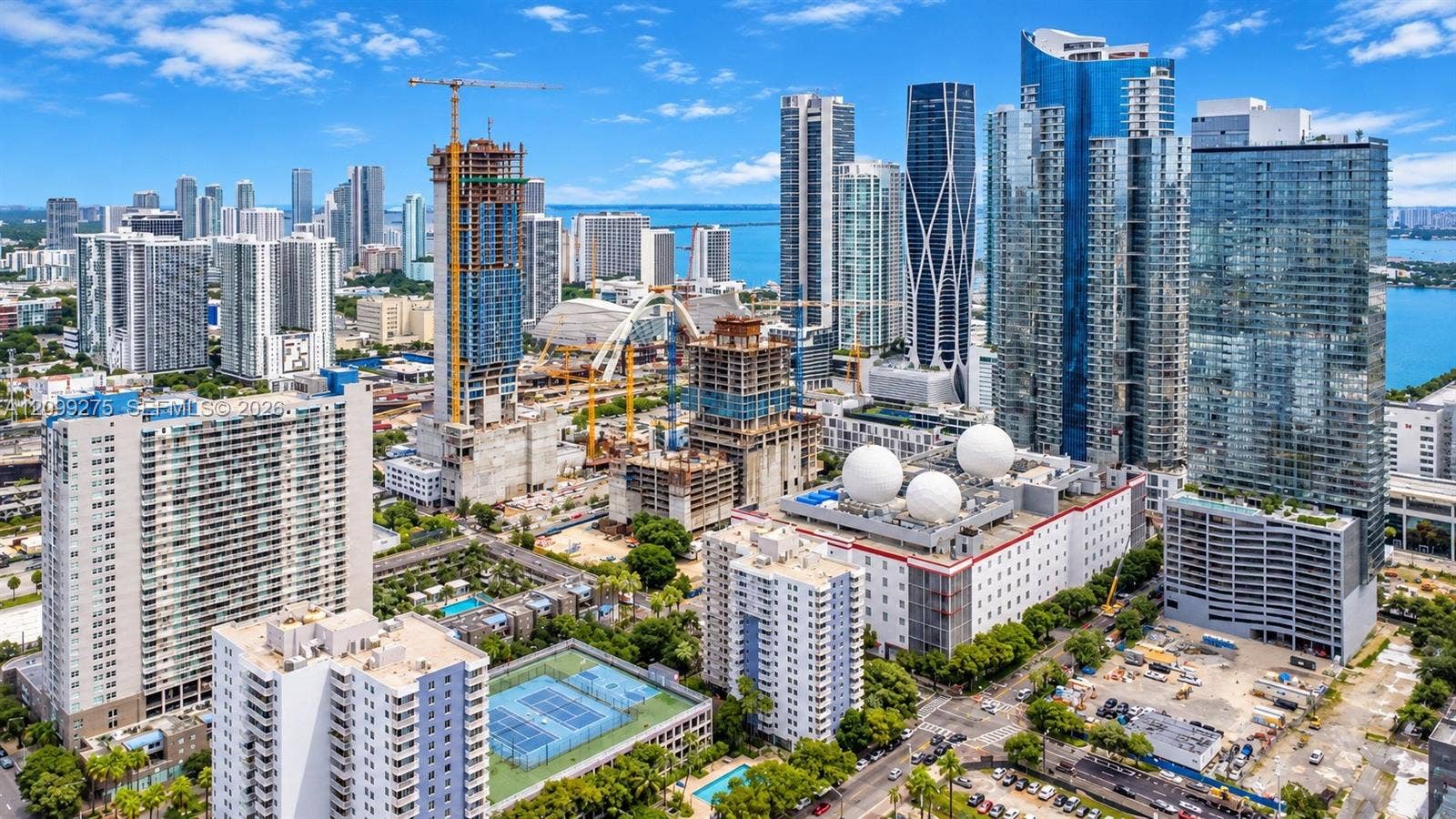 800 N Miami Avenue, #E-902, Miami, Miami, FL 33136 Stunning aerial view of Miamis vibrant skyline, showcasing modern high-rise towers, Biscayne Bay, and ongoing urban development in a dynamic waterfront setting.