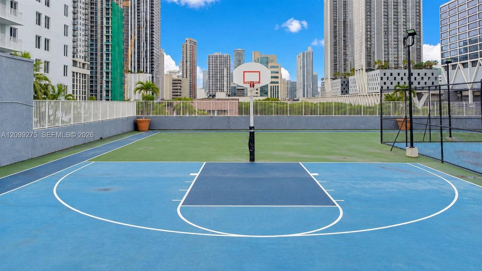800 N Miami Avenue, #E-902, Miami, Miami, FL 33136 Outdoor basketball court with a blue playing surface, surrounded by modern high-rise residences and rooftop tennis facilities, offering residents convenient access to recreational amenities and downtown Miami skyline views.