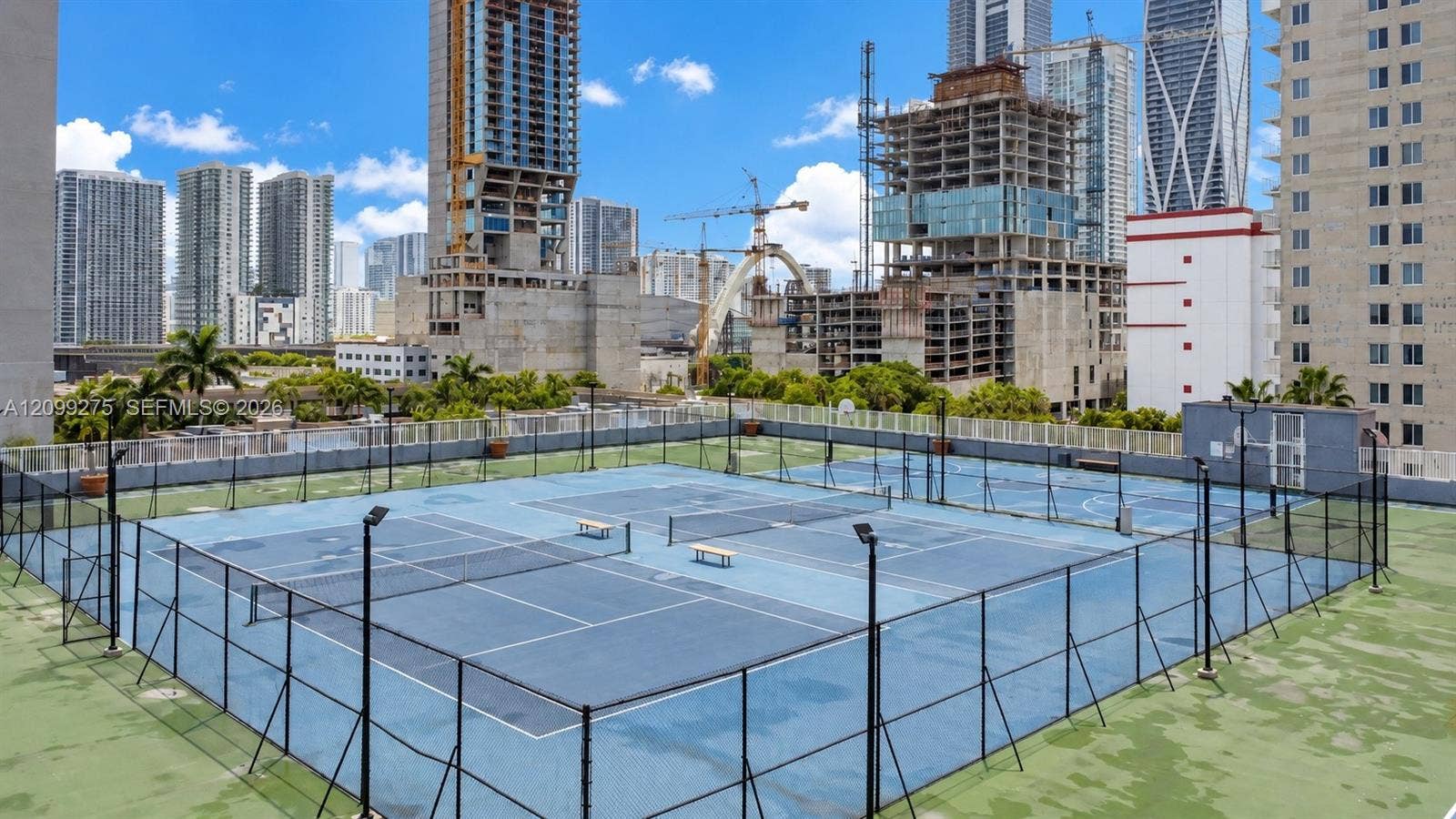 800 N Miami Avenue, #E-902, Miami, Miami, FL 33136 Recreational tennis courts with secure fencing, expansive city skyline views, and surrounding high-rise developments, offering residents an elevated outdoor sports and leisure experience.