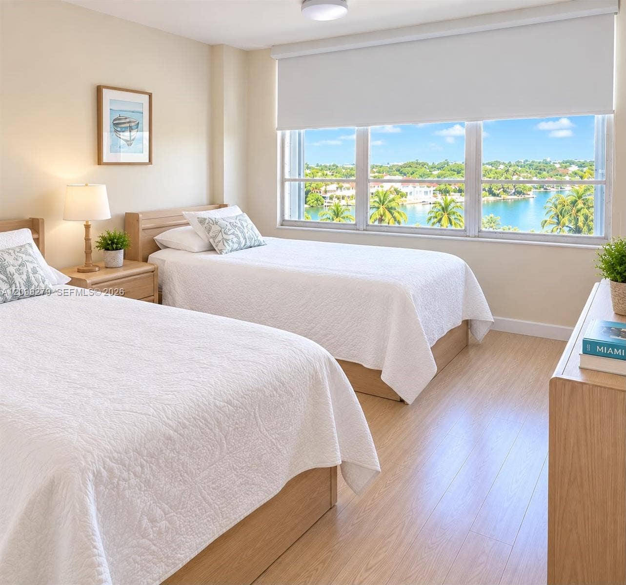 5151 Collins Avenue, #921, Miami Beach, Miami Beach, FL 33140 Neutral-toned interior featuring wood-finish flooring, a large triple-pane window with a retractable roller shade, and panoramic water and landscape scenery