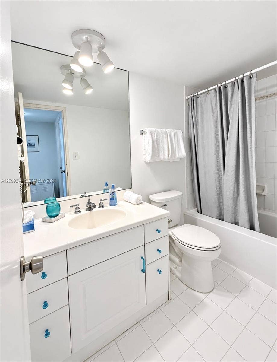 5151 Collins Avenue, #921, Miami Beach, Miami Beach, FL 33140 Bathroom featuring a white vanity with integrated sink, large wall-mounted mirror, multi-light ceiling fixture, and a tiled shower surround