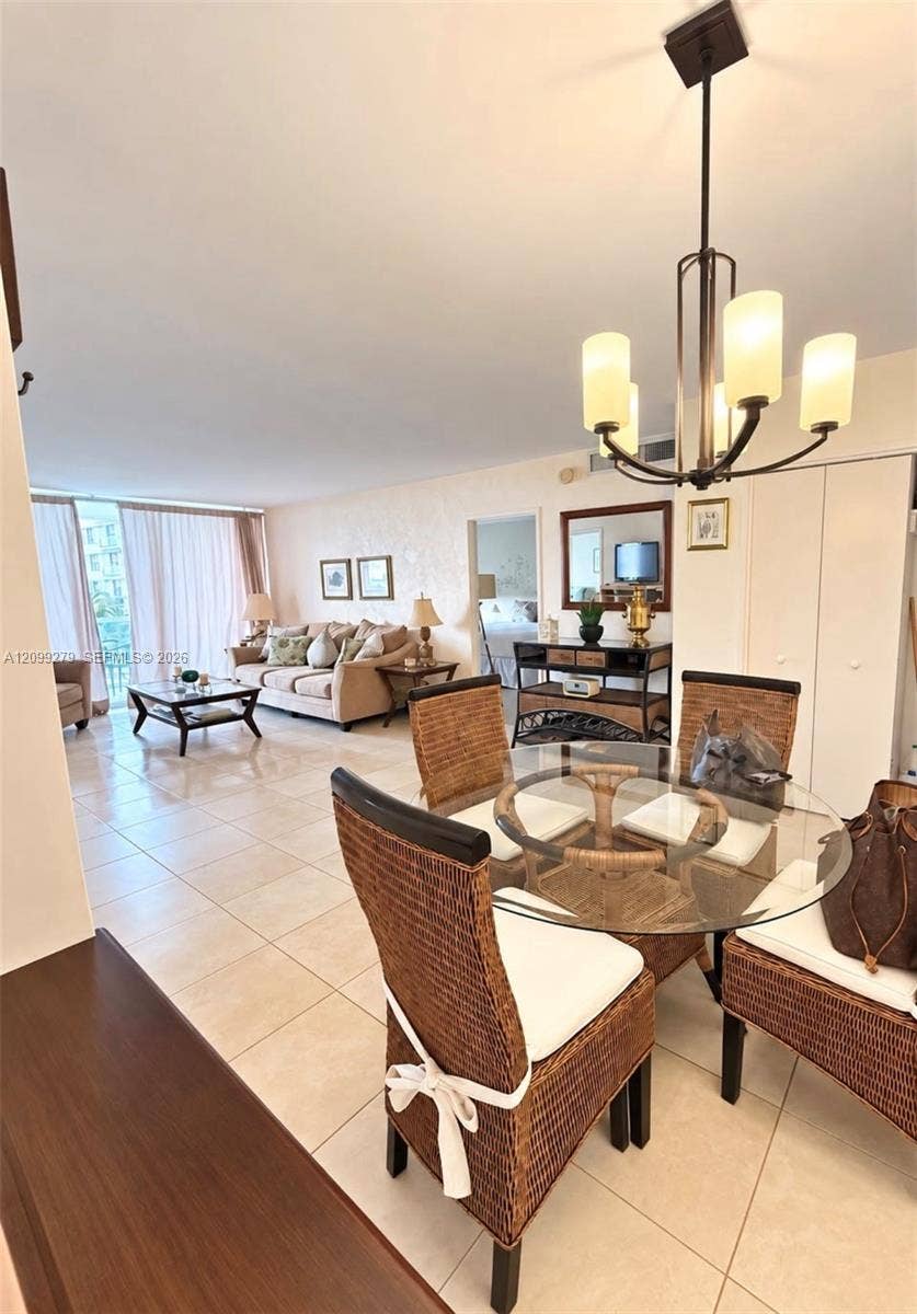 5151 Collins Avenue, #921, Miami Beach, Miami Beach, FL 33140 Open-concept living space featuring large-format tile flooring, a multi-light metal chandelier, and floor-to-ceiling glass sliding doors