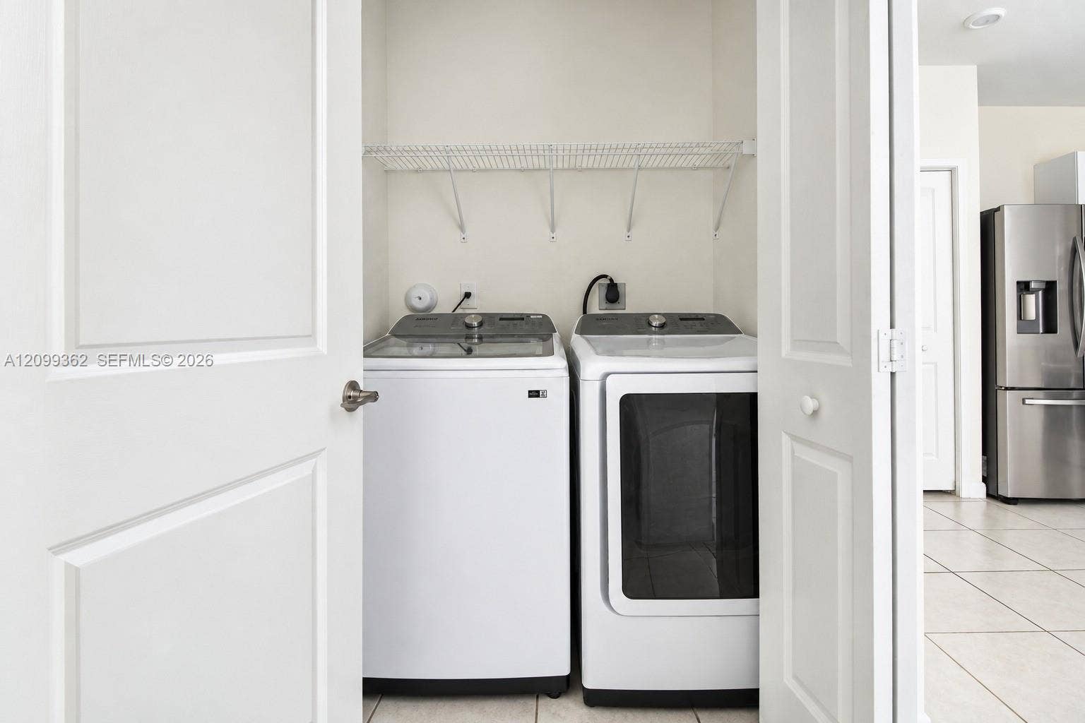 16230 SW 290th Terrace, Homestead, FL 33033 Laundry closet featuring white bifold doors, wire shelving, and tile flooring