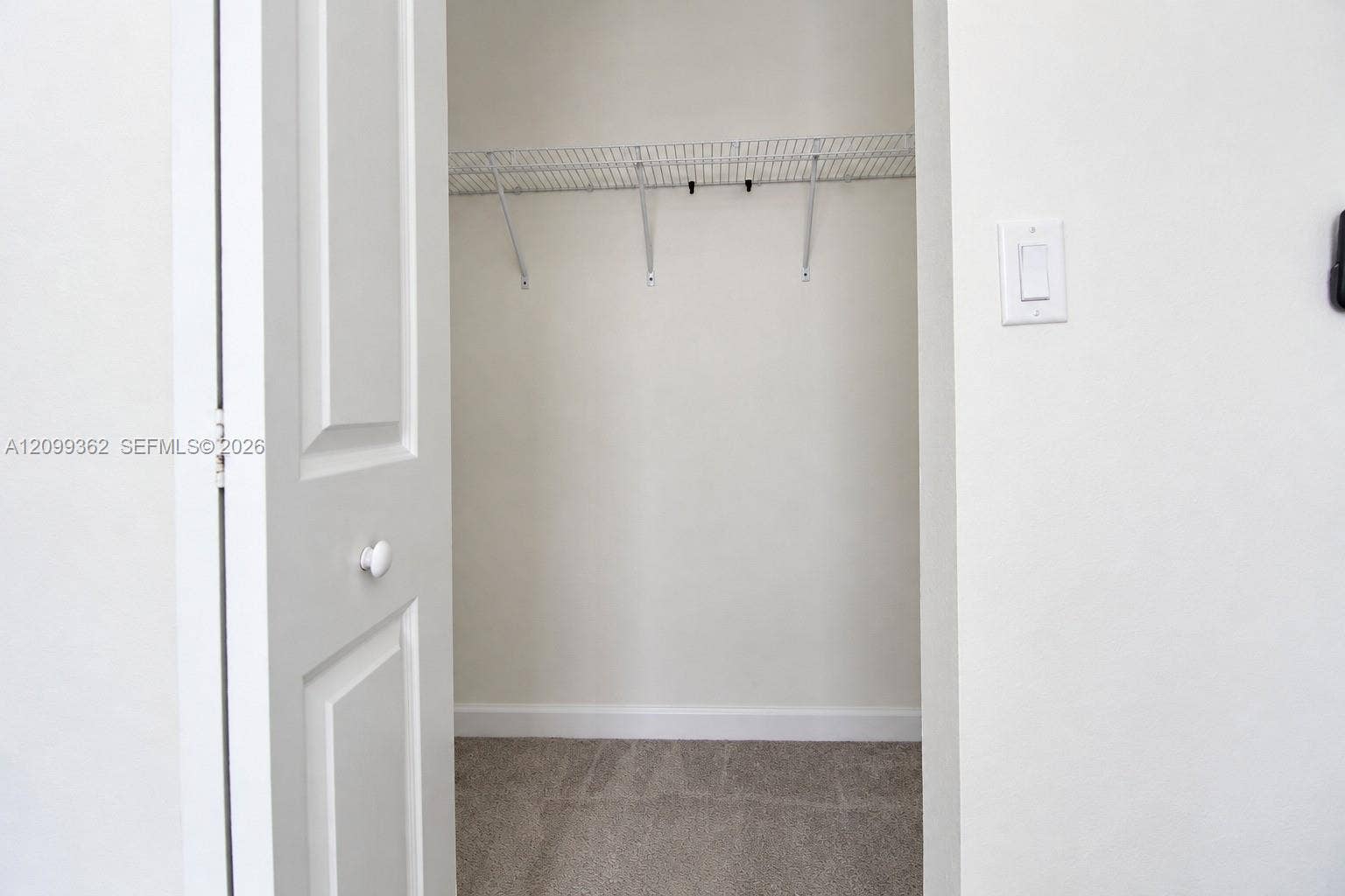 16230 SW 290th Terrace, Homestead, FL 33033 Storage space featuring a two-panel interior door, wall-mounted wire shelving, and carpeting