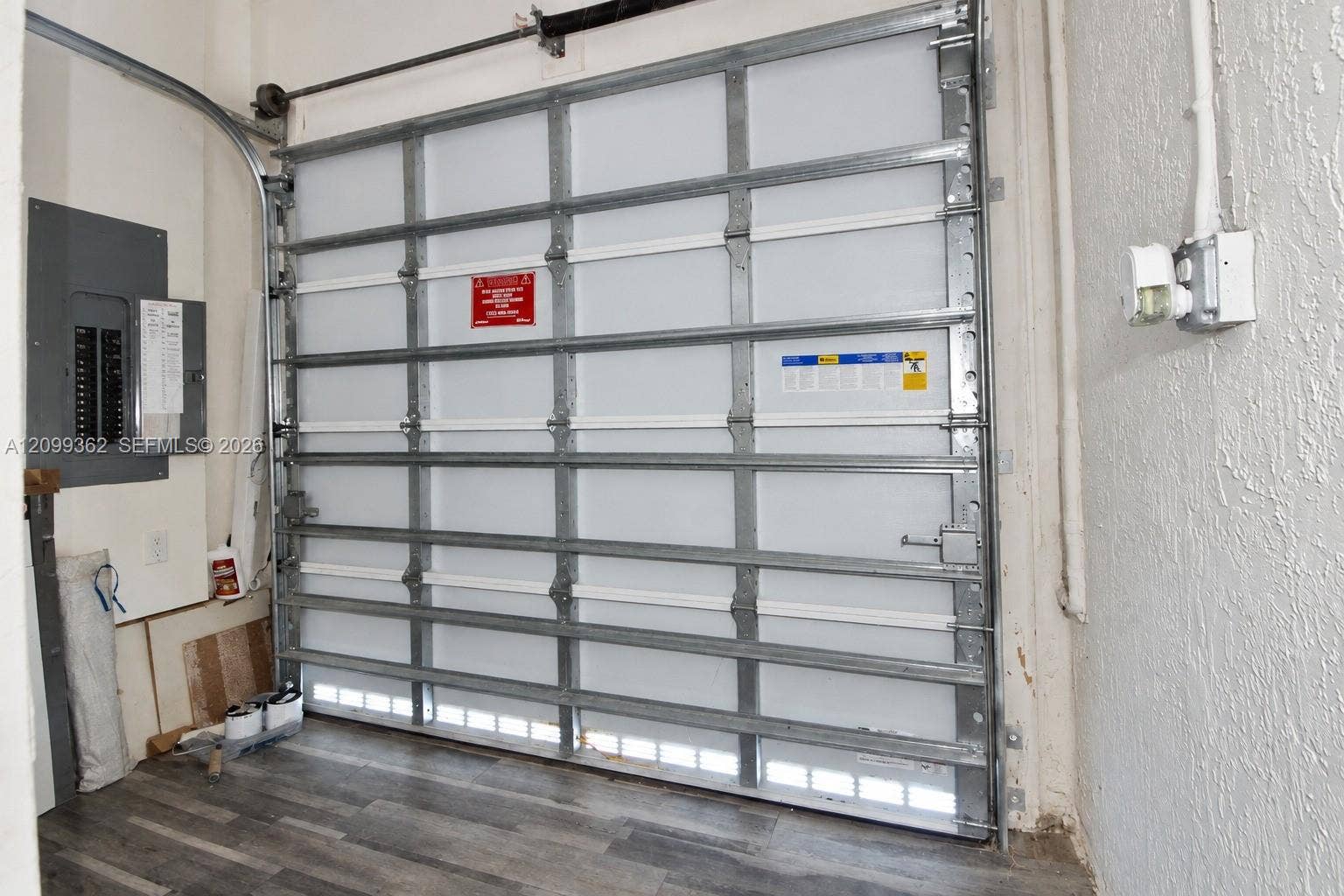 16230 SW 290th Terrace, Homestead, FL 33033 Sectional garage door with metal tracking, installed electrical panel, and wood-finish flooring