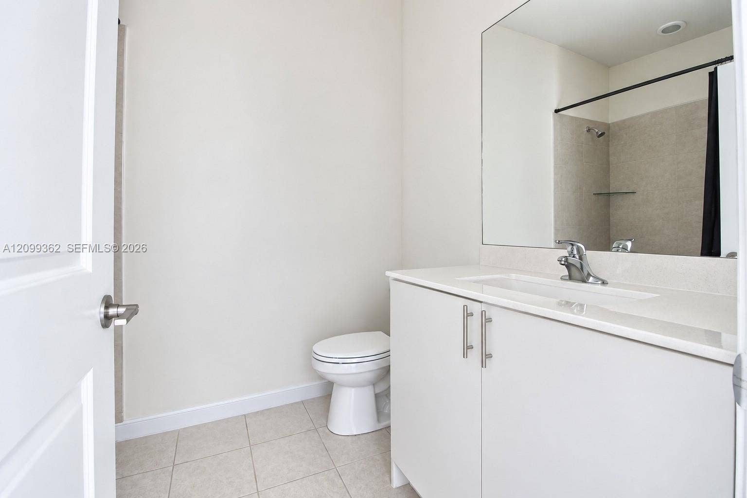 16230 SW 290th Terrace, Homestead, FL 33033 Bathroom featuring a vanity with white cabinetry, light-toned countertop, integrated sink, polished metal faucet, and wall-to-wall mirror