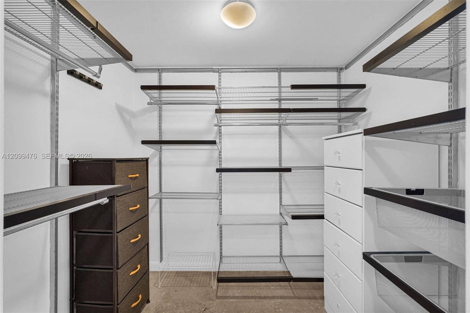 Walk-in storage space featuring adjustable metal shelving and a flush-mount ceiling light