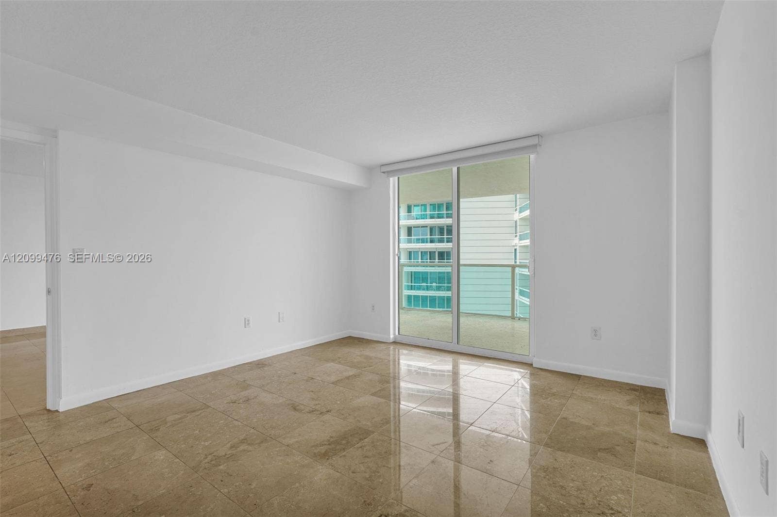 Living space featuring large-format tile flooring and sliding glass doors with access to an exterior balcony