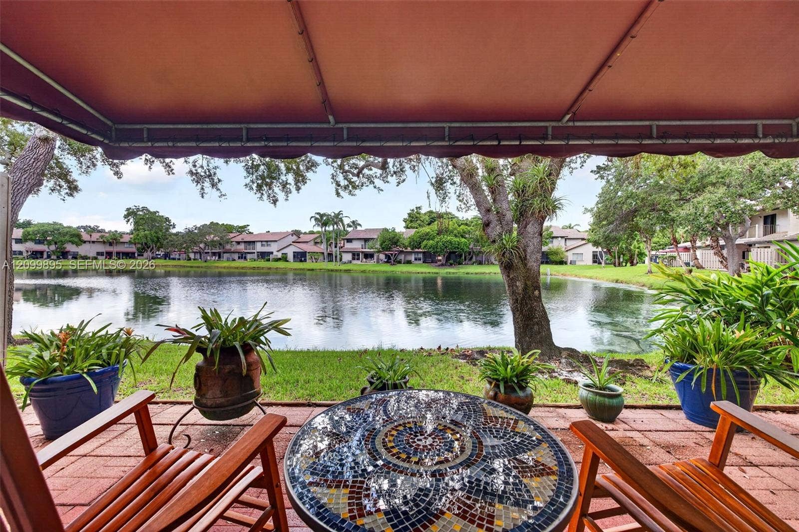 9012 Vineyard Lake Drive, Plantation, FL 33324 Serene lake views create a peaceful backdrop from the home's outdoor living space.