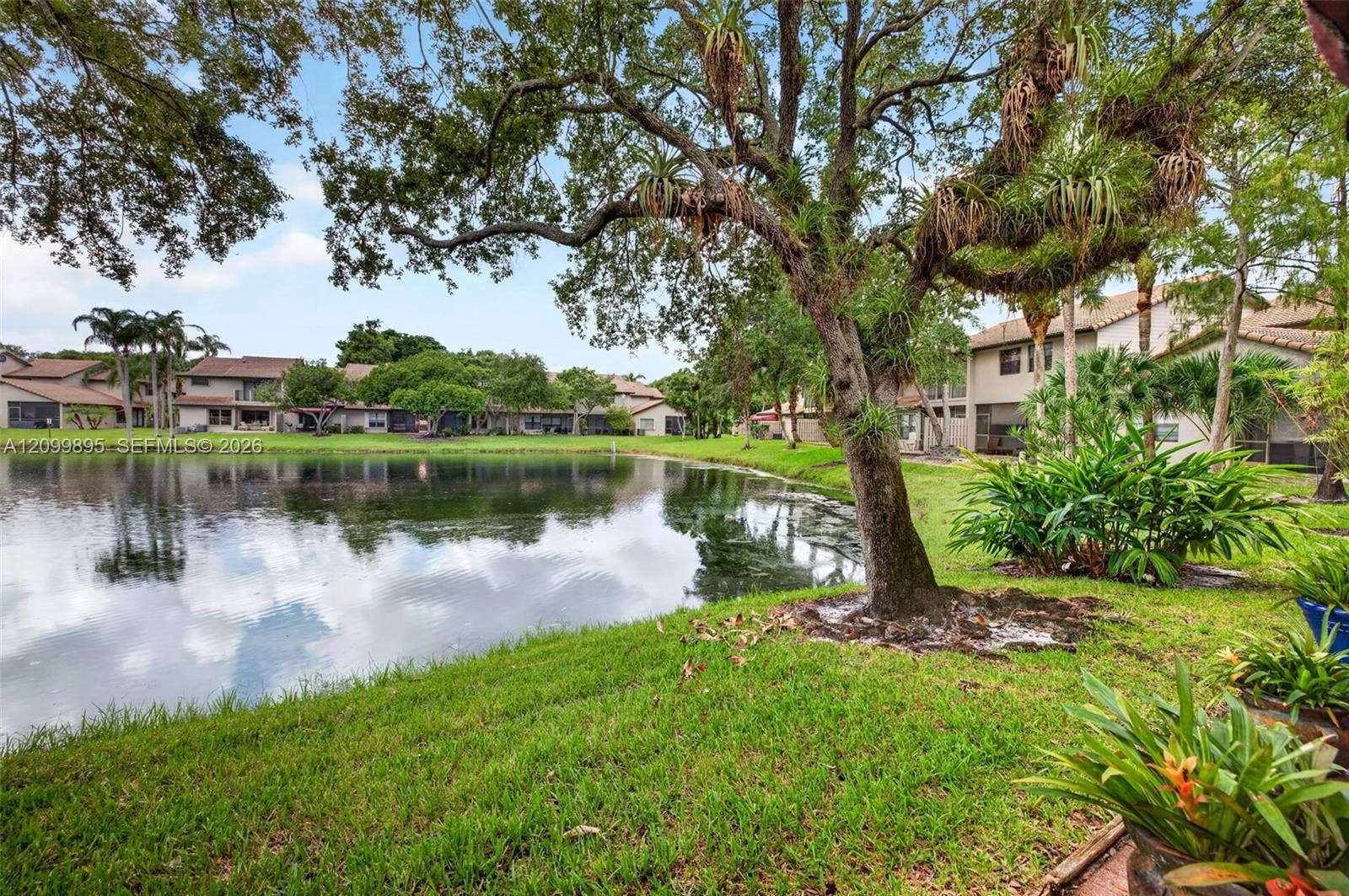 9012 Vineyard Lake Drive, Plantation, FL 33324 Serene lake views create a peaceful backdrop from the home's outdoor living space.