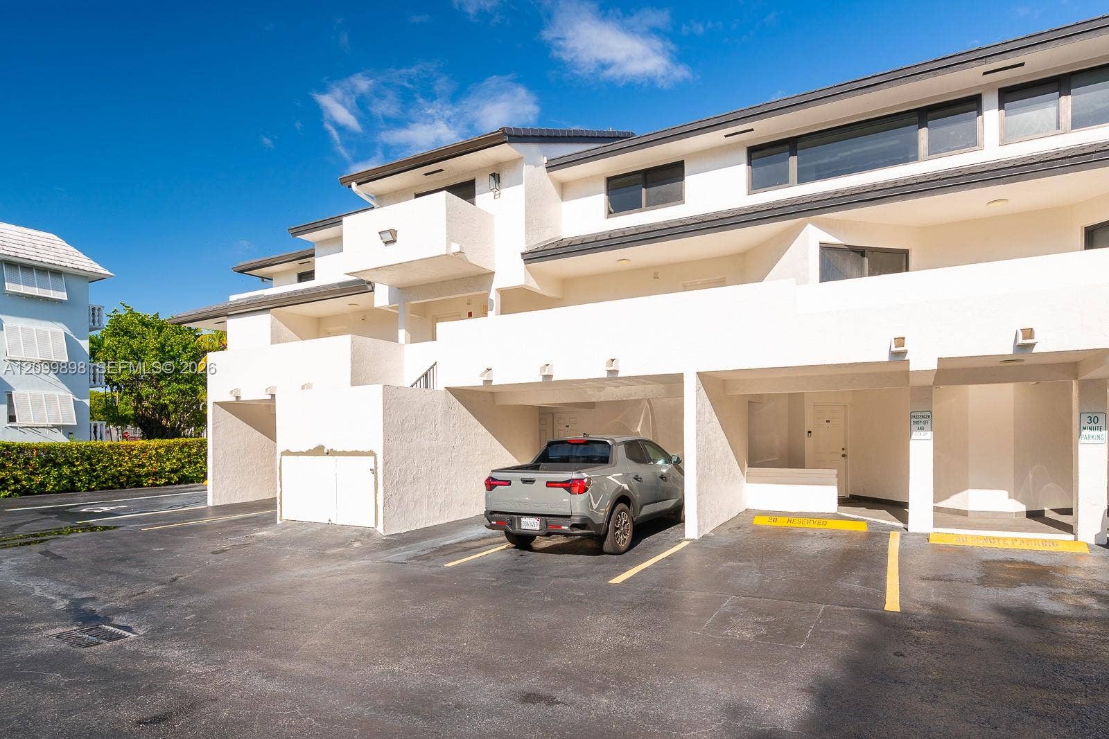 5750 Turin Street, #206, Coral Gables, FL 33146 Unit 206 parking space # 20 is shown in this picture to the right of the gray car. Notice that the building shields about 1/2 of the car from our tropical weather! The Balcony you see to the left of the parking space is the balcony to the Primary bedroom located on the South side of the building overlooking a quiet residential neighborhood!!