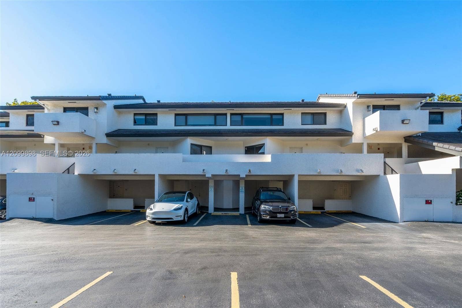 5750 Turin Street, #206, Coral Gables, FL 33146 Parking space is #20 & is between the white Tesla and the dark blue BMW! The "Primary Bedroom" has the large balcony to the left of the white Tesla and only 1 other unit in the building has the extended balcony looks out to the South East skyline at treetop heights overlooking a quiet residential neighborhood!