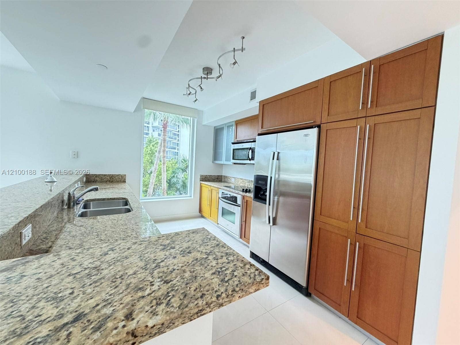 2821 N Ocean Boulevard, #305S, Fort Lauderdale, Fort Lauderdale, FL 33308 Kitchen featuring wood cabinetry, stone countertops, stainless steel appliances, a double-basin sink, and track lighting