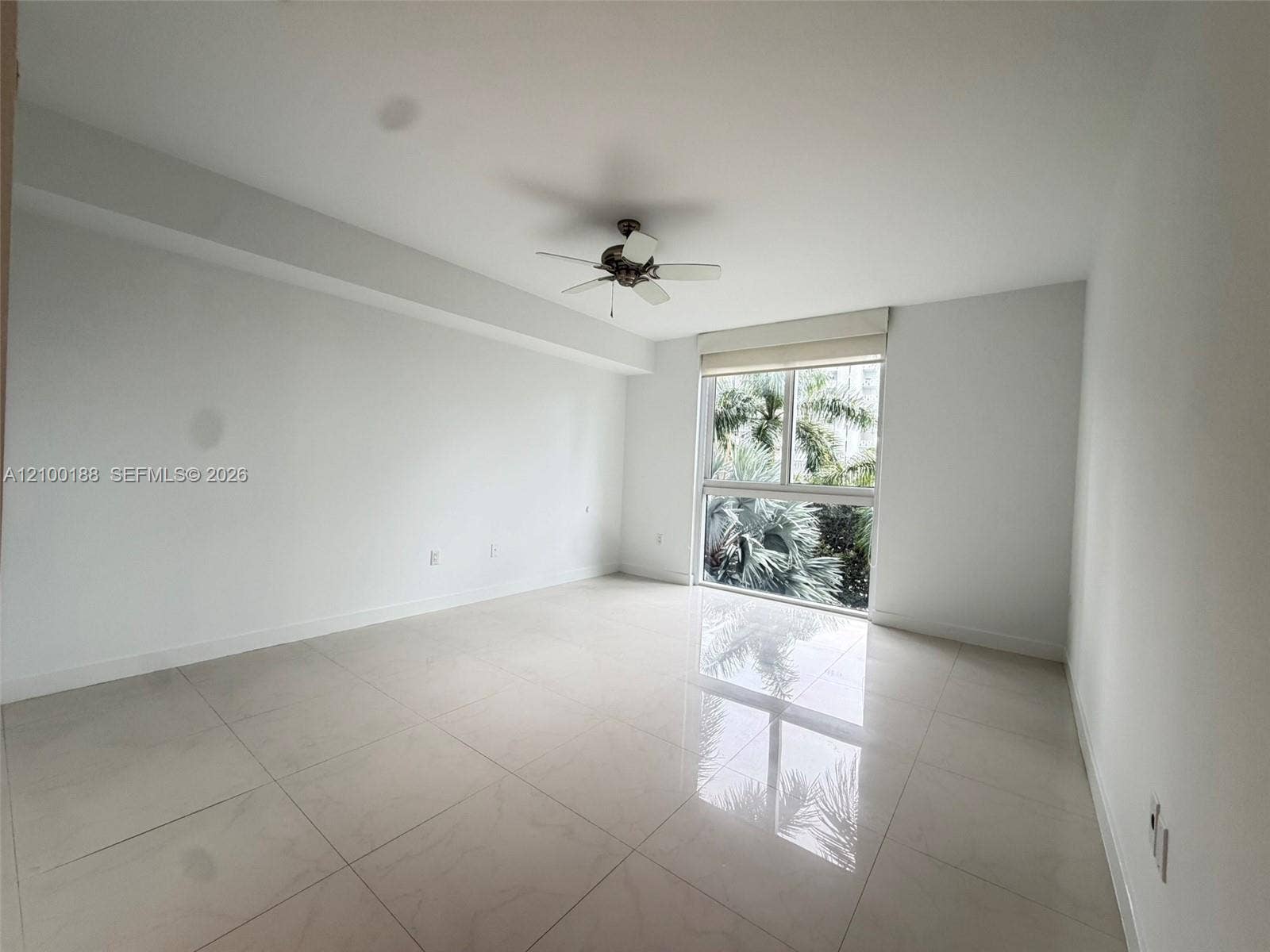 2821 N Ocean Boulevard, #305S, Fort Lauderdale, Fort Lauderdale, FL 33308 Neutral-toned interior space featuring polished tile flooring, ceiling-mounted fan, and floor-to-ceiling windows