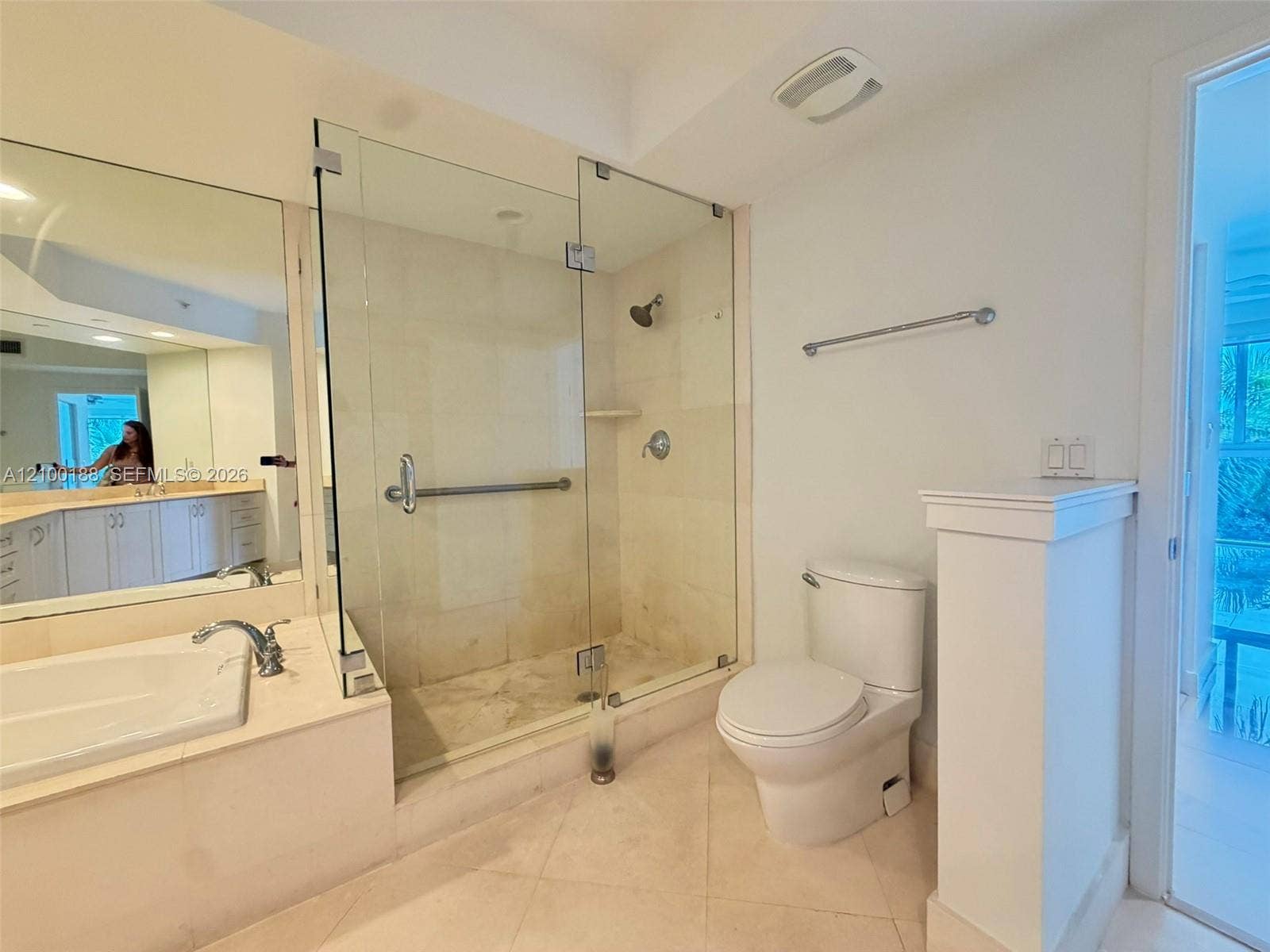 2821 N Ocean Boulevard, #305S, Fort Lauderdale, Fort Lauderdale, FL 33308 Bathroom featuring a tiled shower stall with a glass enclosure, built-in soaking tub with stone surround, wall-to-wall vanity mirror, and neutral tile flooring