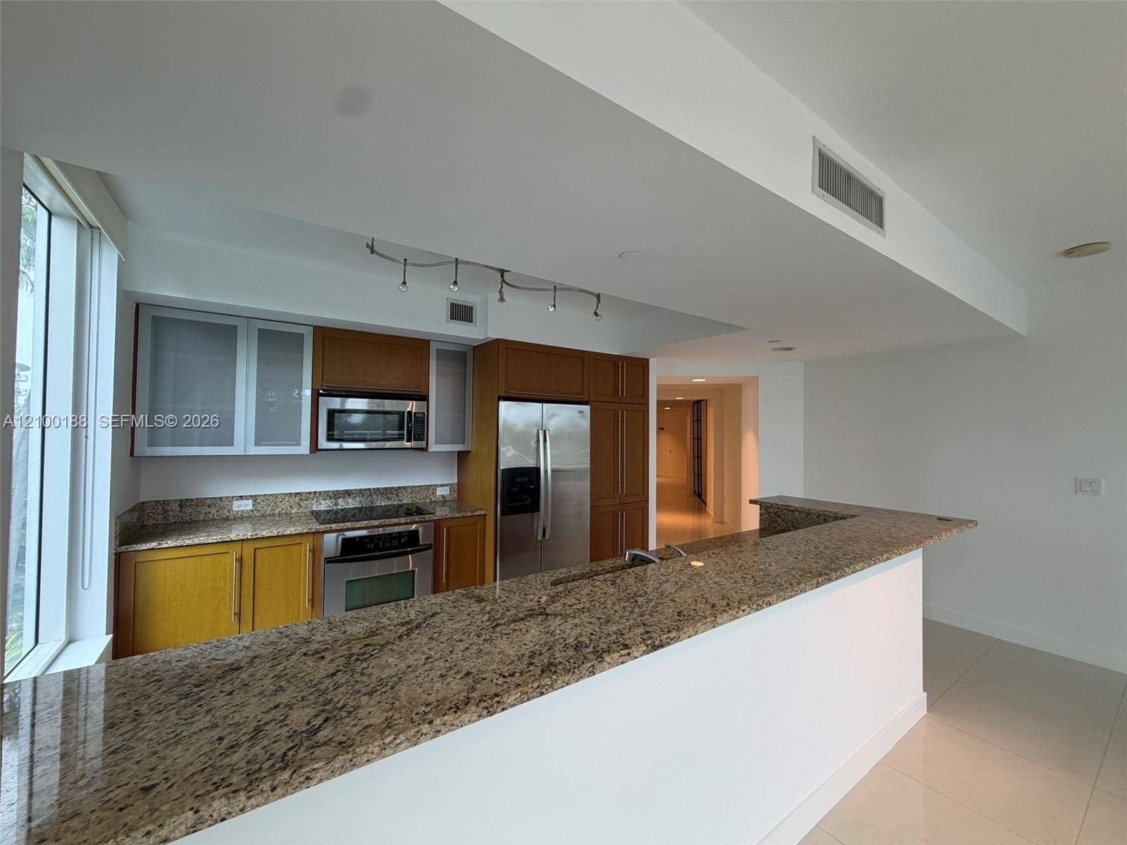 2821 N Ocean Boulevard, #305S, Fort Lauderdale, Fort Lauderdale, FL 33308 Kitchen featuring wood cabinetry, stone countertops, stainless steel appliances, a breakfast bar, and tile flooring