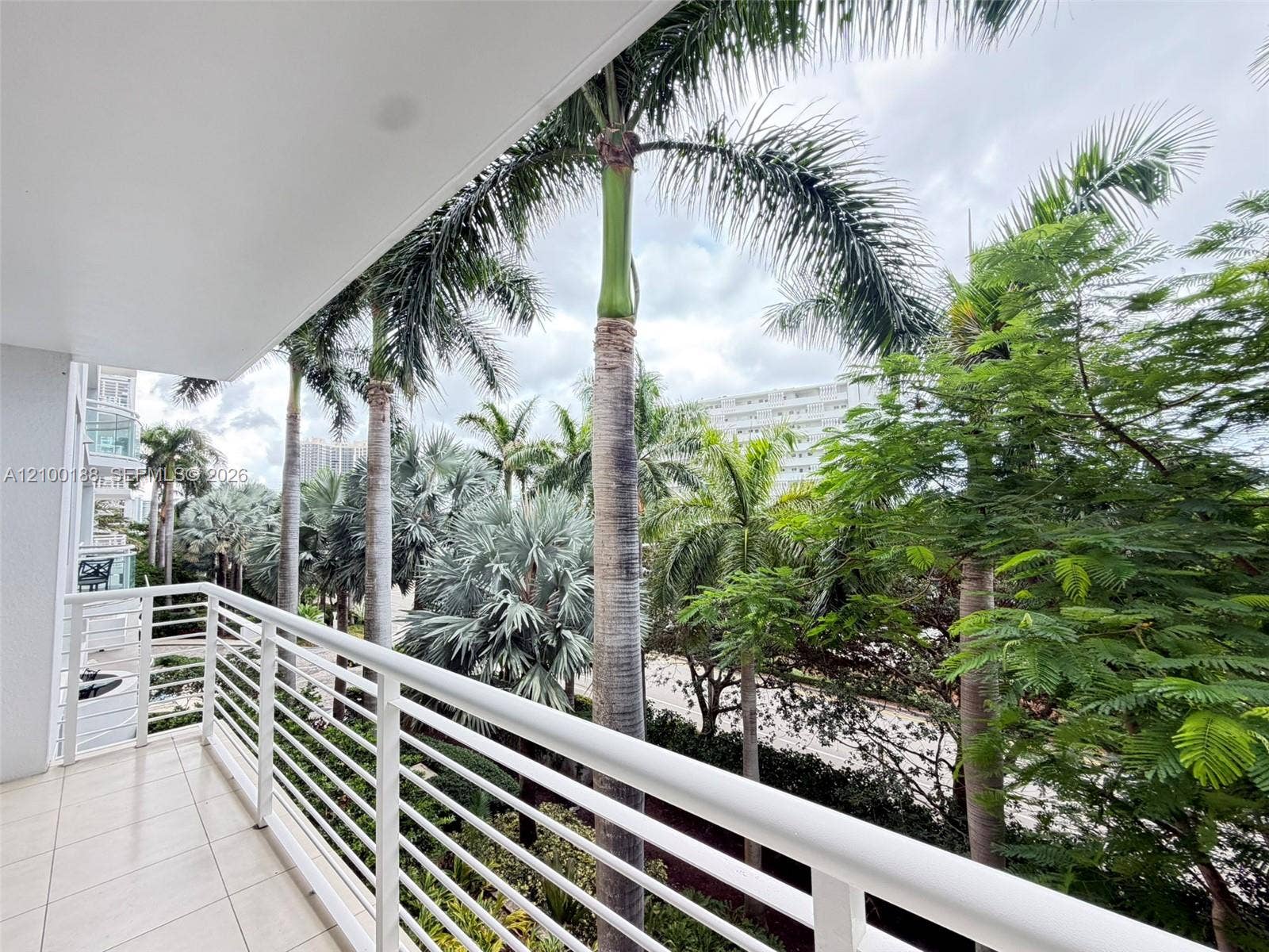 2821 N Ocean Boulevard, #305S, Fort Lauderdale, Fort Lauderdale, FL 33308 Private balcony featuring white horizontal railings, tile flooring, and mature palm trees