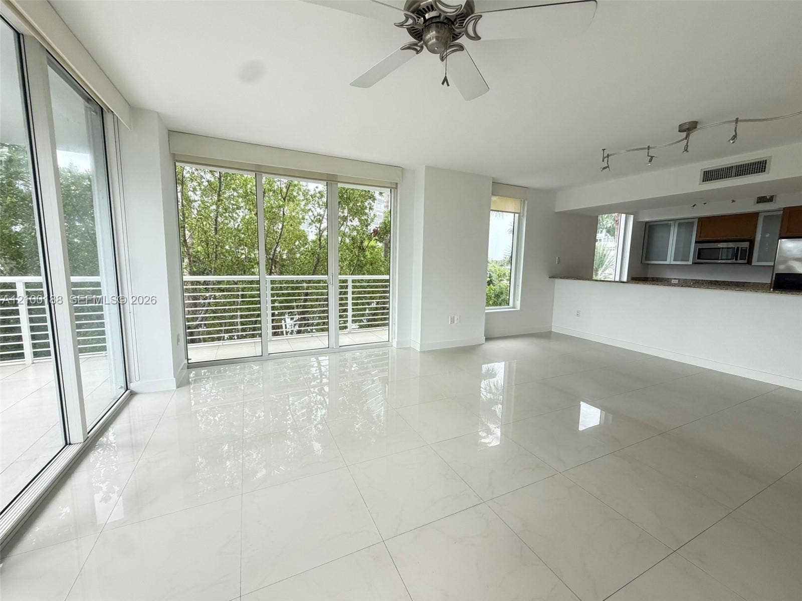 2821 N Ocean Boulevard, #305S, Fort Lauderdale, Fort Lauderdale, FL 33308 Open-concept interior featuring large-format tile flooring, floor-to-ceiling glass sliding doors, a breakfast bar with stone-finish countertops, and a track lighting system