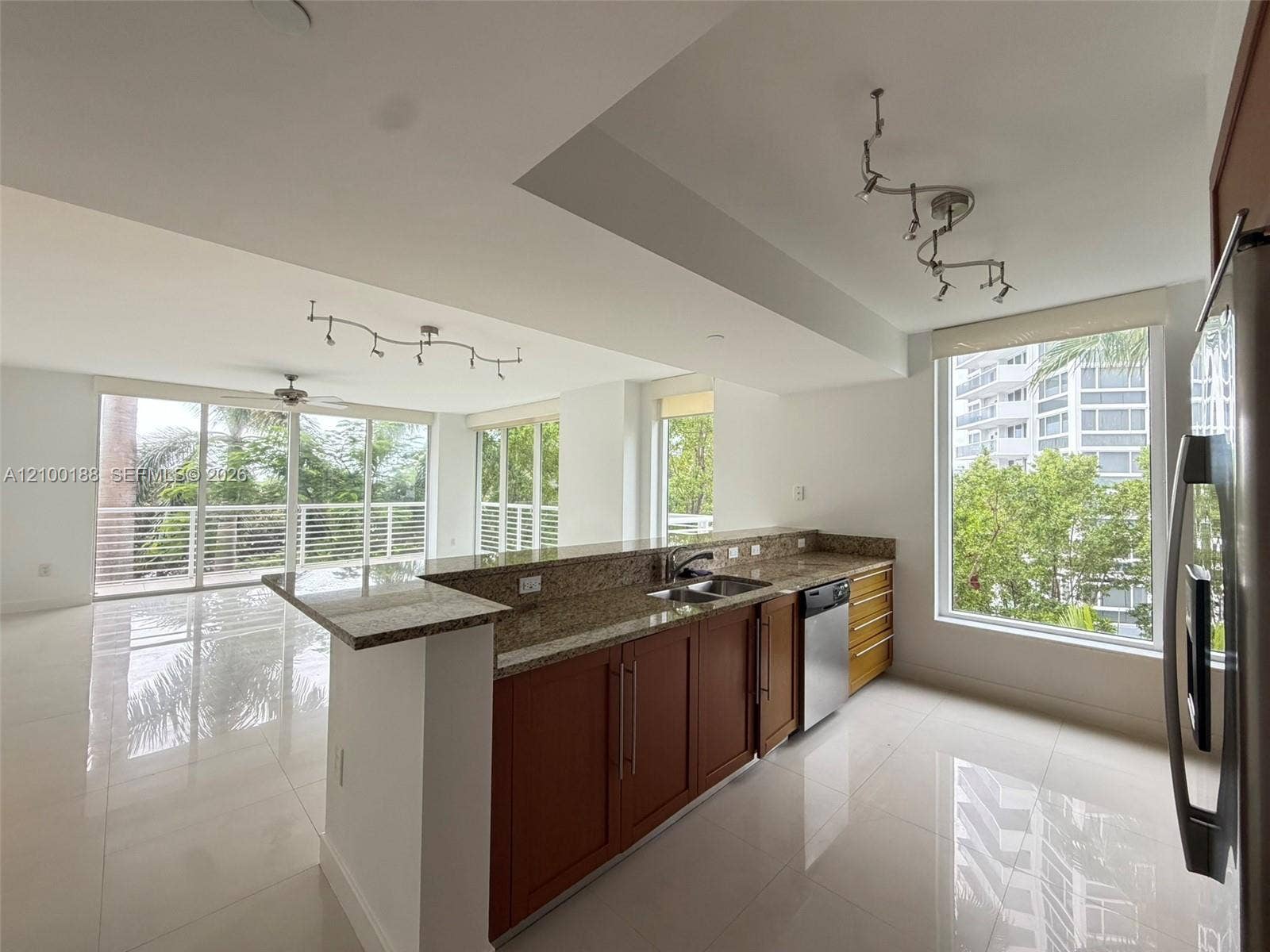 2821 N Ocean Boulevard, #305S, Fort Lauderdale, Fort Lauderdale, FL 33308 Kitchen featuring natural stone countertops, wood cabinetry, large-format tile flooring, track lighting, and floor-to-ceiling windows